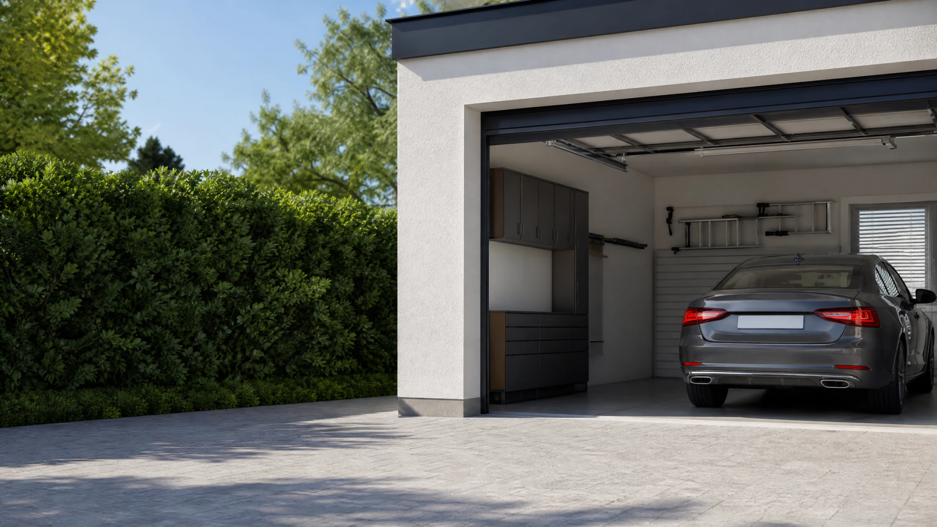 A dark grey sedan parked inside a tidy open garage with built-in cabinetry and a glass-panel overhead door.