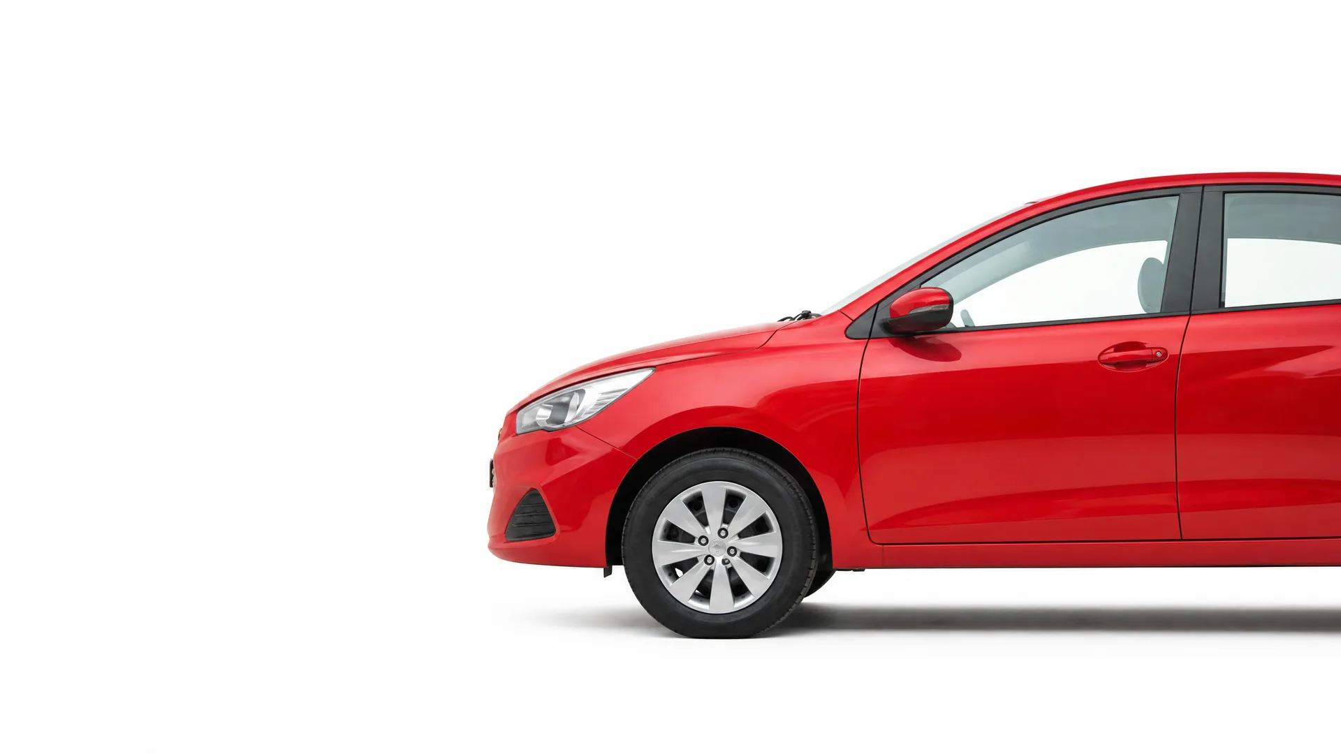 Front half of a red four-door car shown in side profile against a plain white background, with the rear of the vehicle cropped off at the right edge.