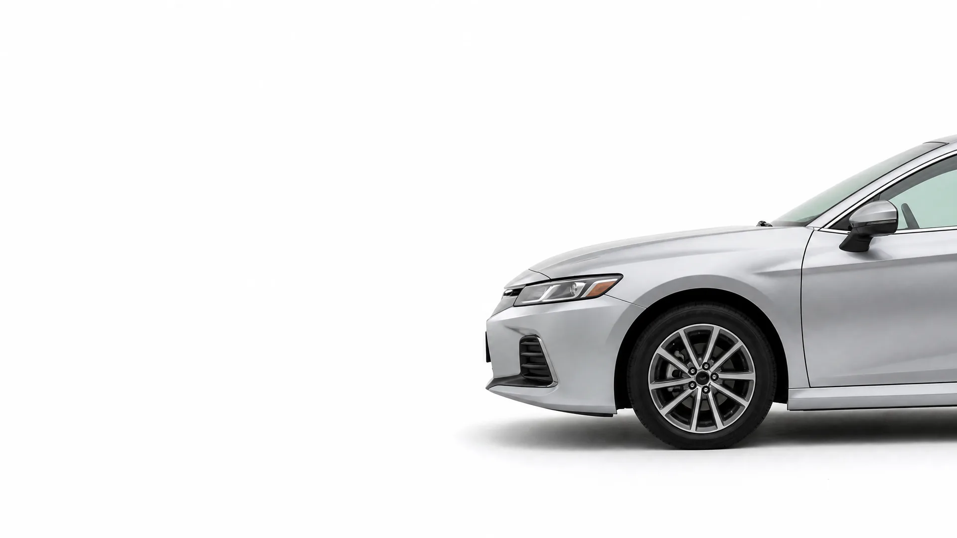 Front half of a silver four-door sedan, shown in profile against a plain white background with a soft shadow beneath.
