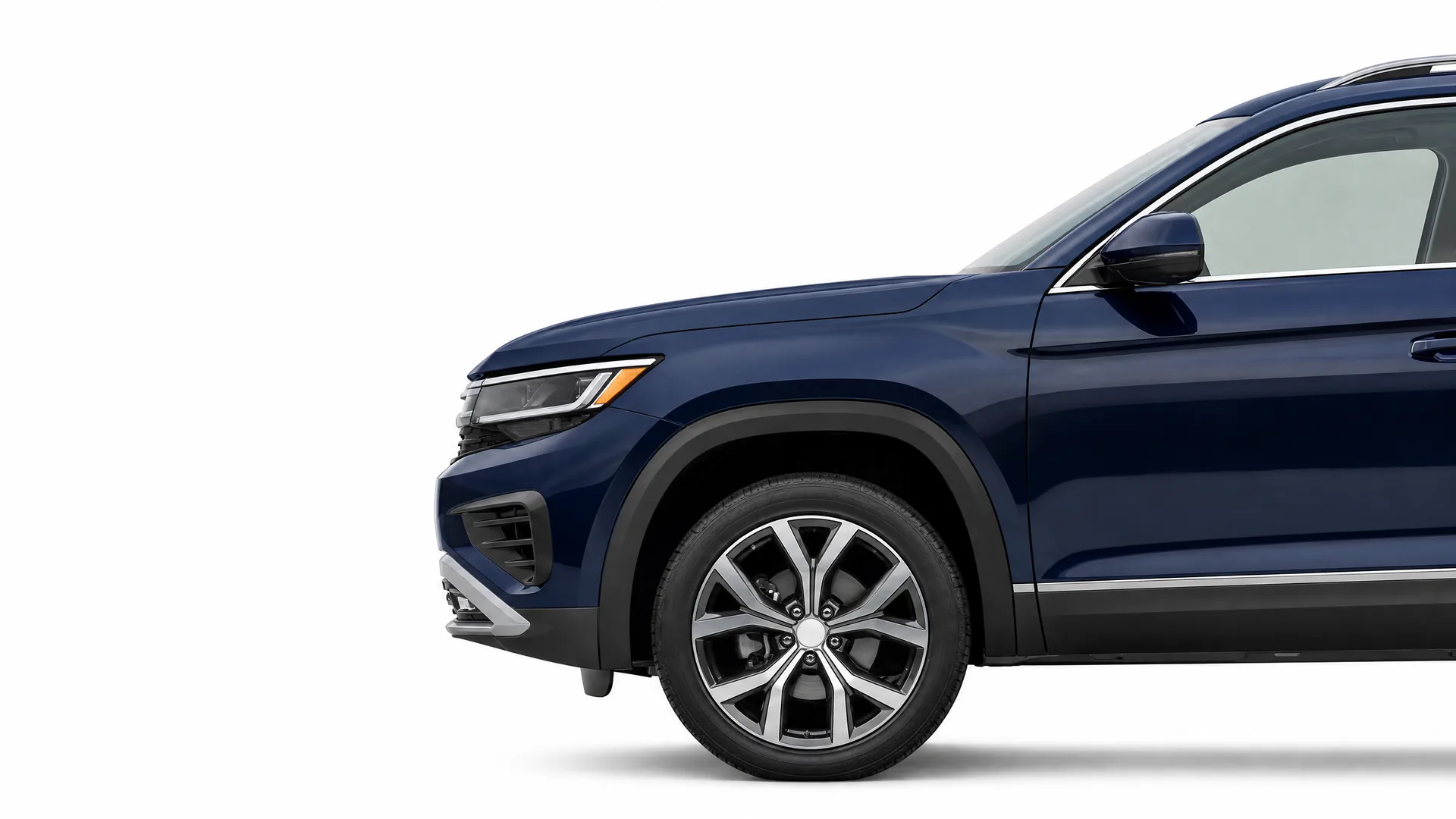Front half of a dark blue SUV shown in profile against a plain white background, with alloy wheel, headlight and side mirror visible.