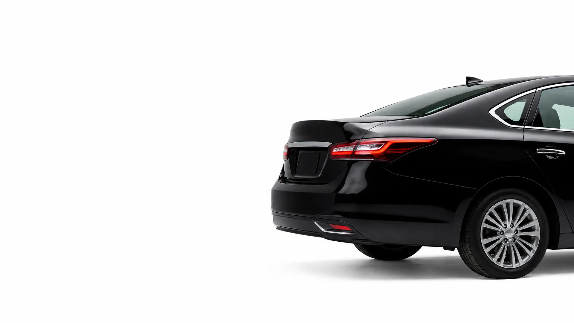 Rear three-quarter view of a black four-door sedan against a plain white background.