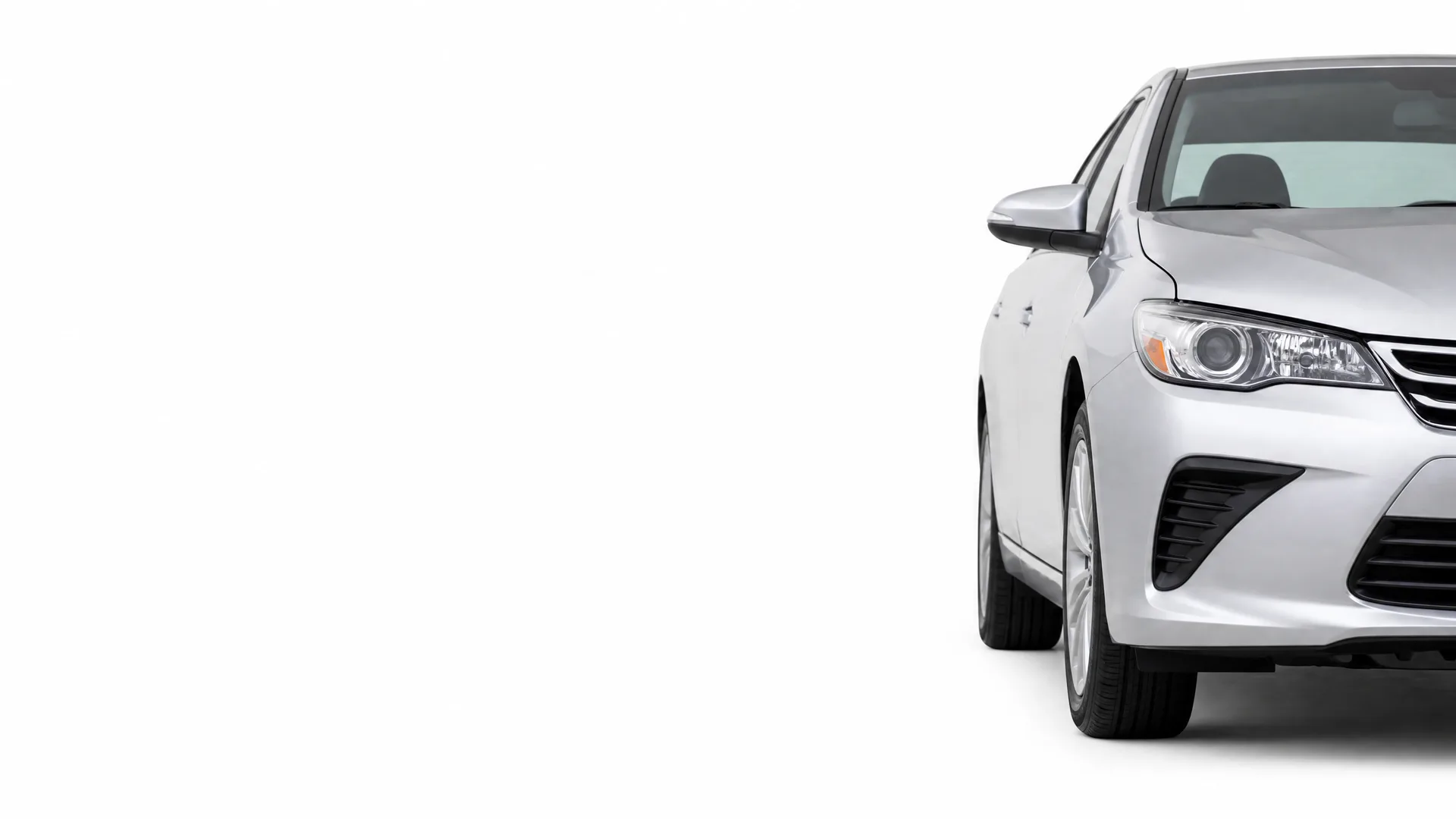Front right portion of a silver four-door sedan on a plain white background, with the rest of the frame empty.