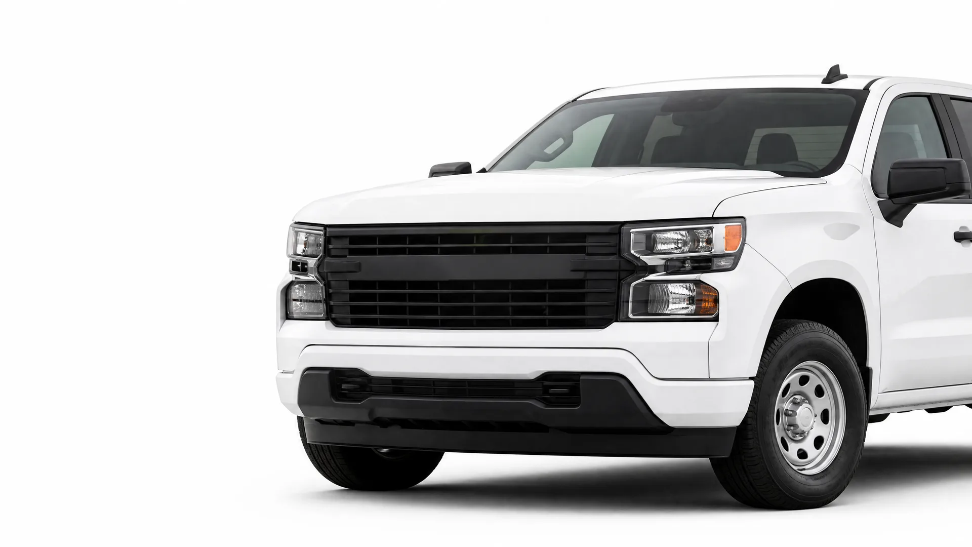 Front three-quarter view of a white pickup truck with a black grille, black bumper trim and steel wheels, isolated on a plain white background.