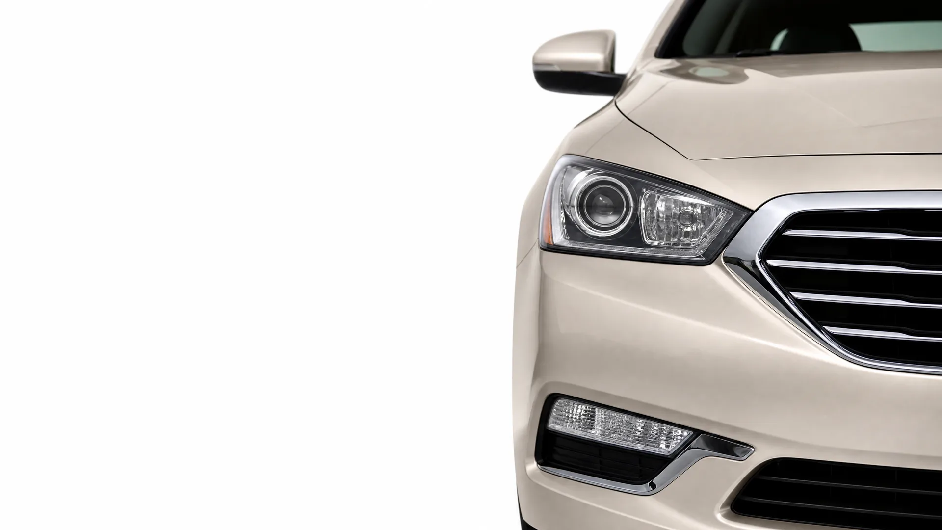 Front right section of a light beige sedan, showing the headlight, grille, fog lamp and side mirror, against a plain white background.