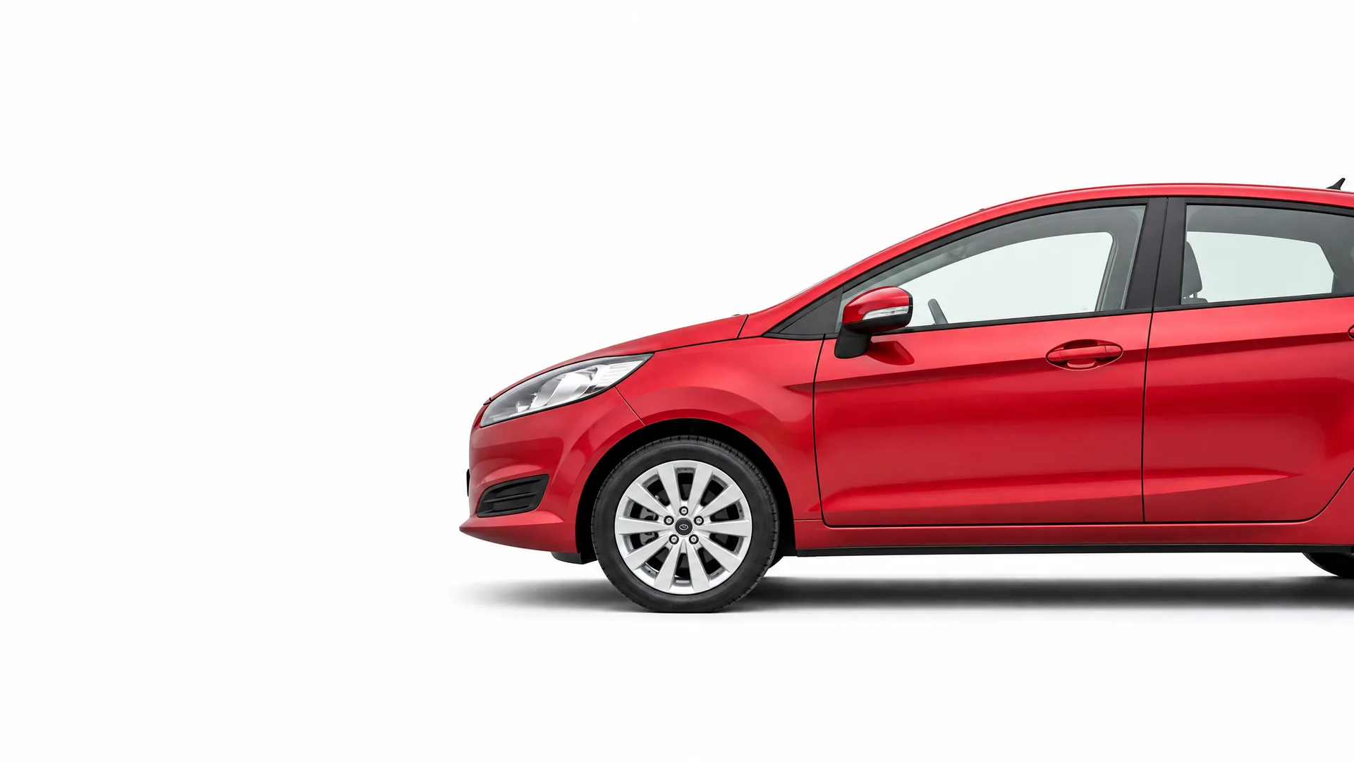 Partial side view of a red hatchback car, showing the front half with alloy wheel and side mirror, against a plain white background.