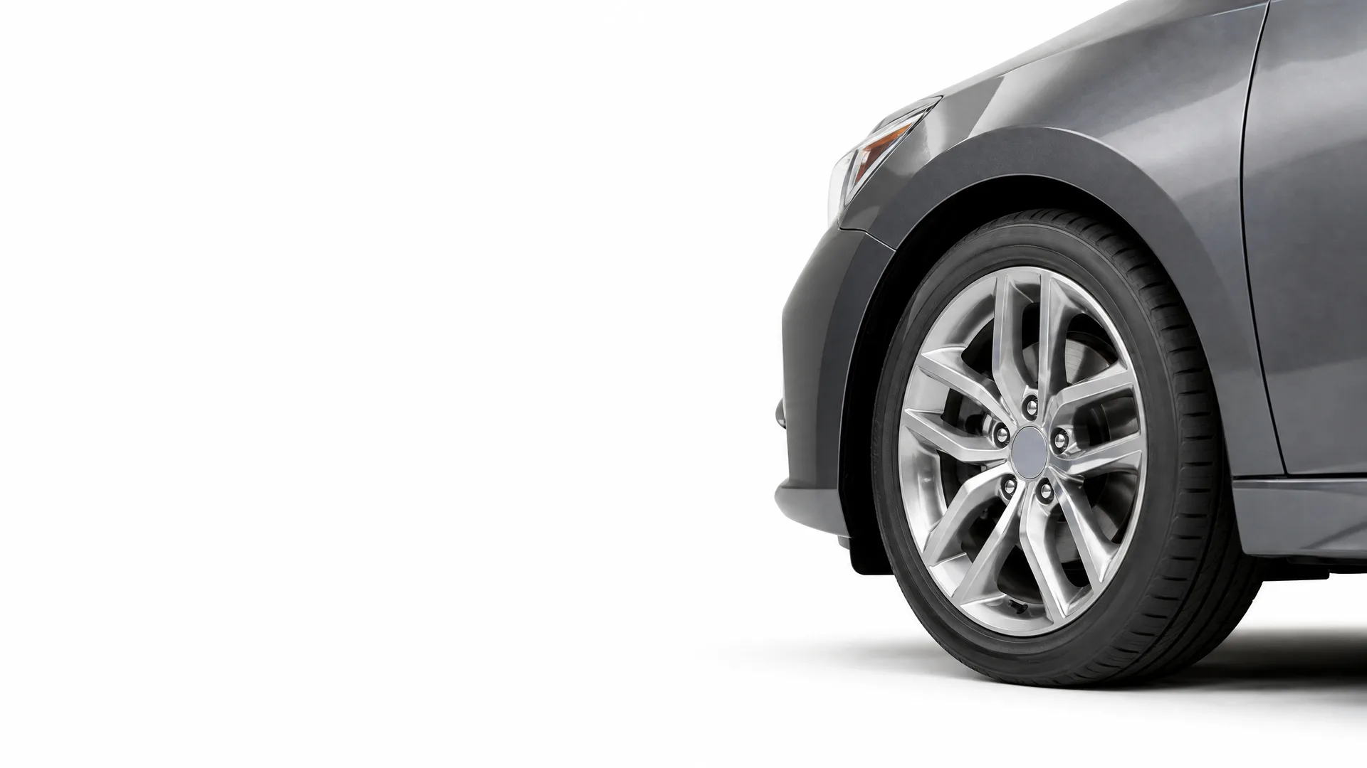 Front corner of a dark gray car with an alloy wheel, shown against a plain white background.