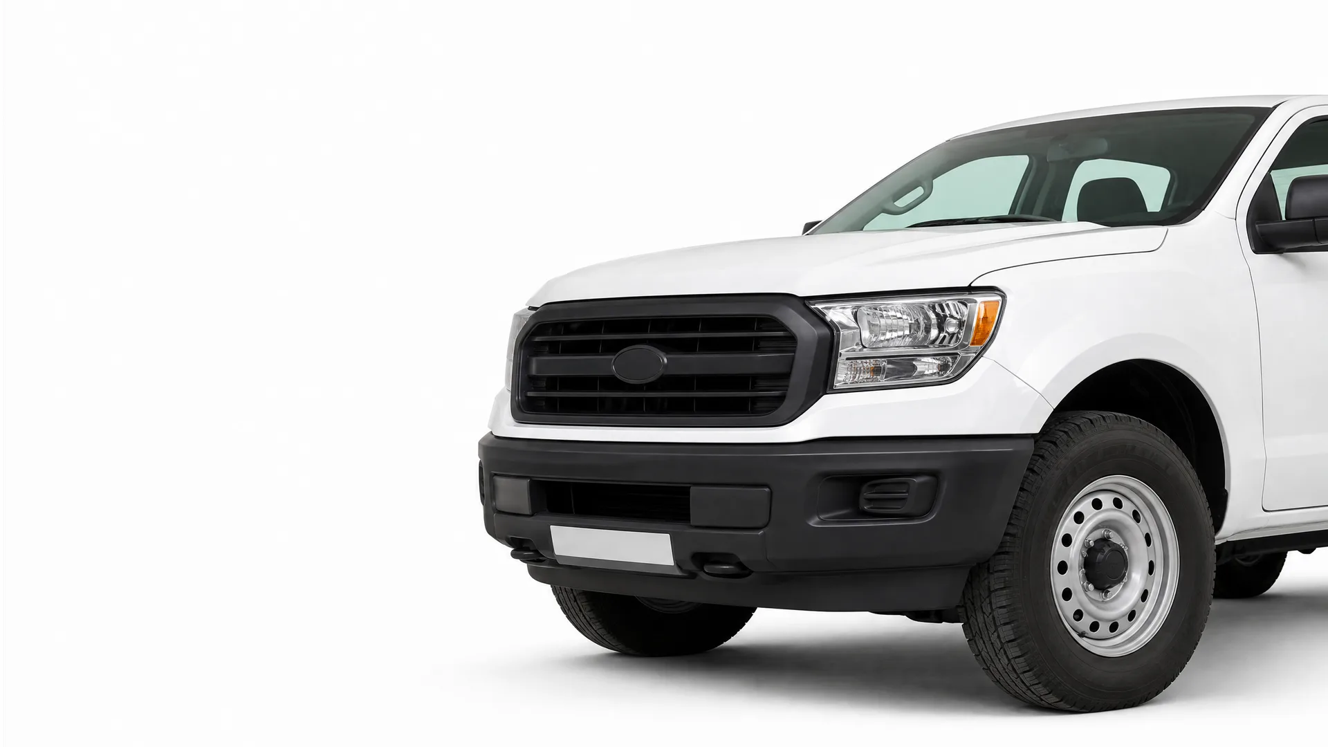 Front half of a white pickup truck with a black grille and bumper and steel wheels, photographed against a plain white background.