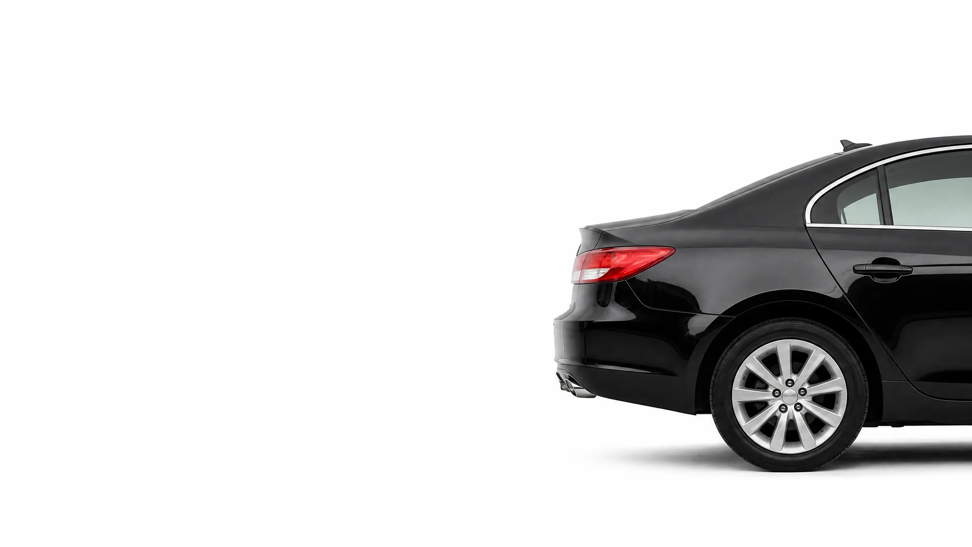Rear three-quarter view of a black sedan, cropped at the front, against a plain white background.