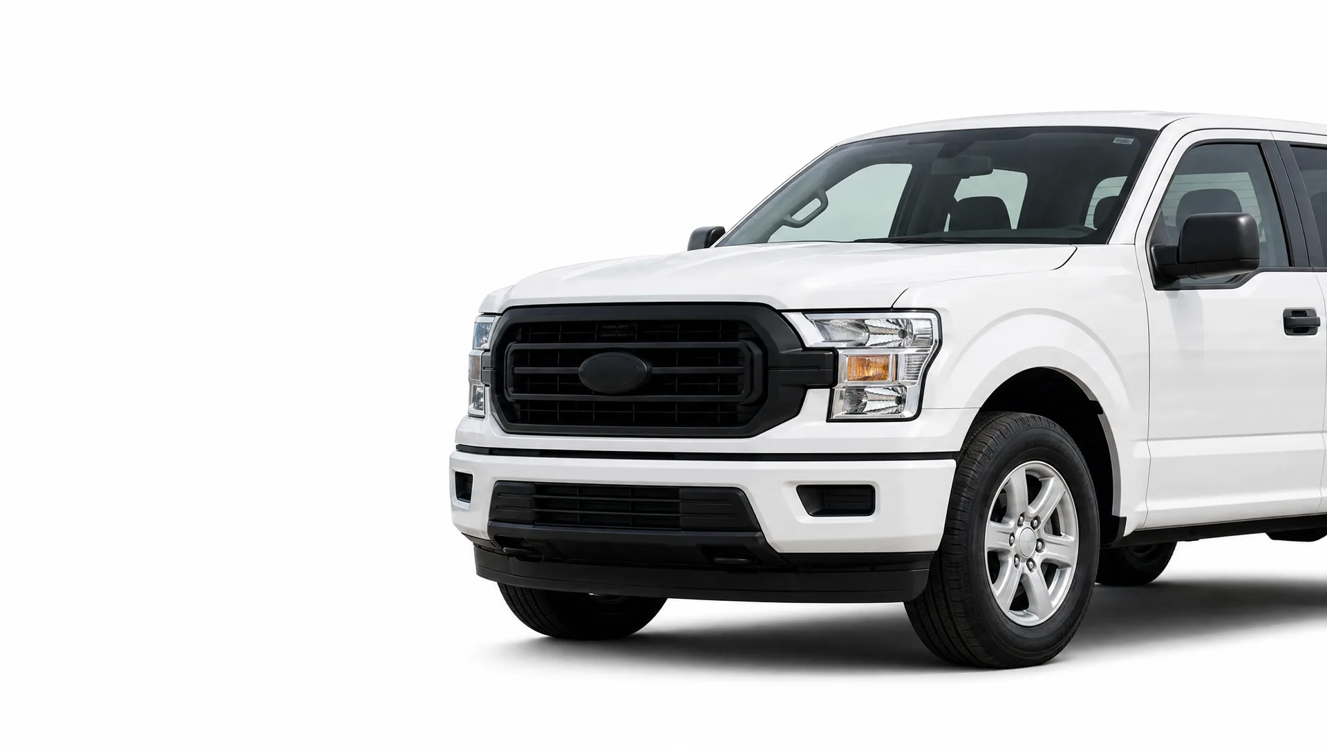 Front three-quarter view of a white crew-cab pickup truck with a black grille and alloy wheels on a plain white background.