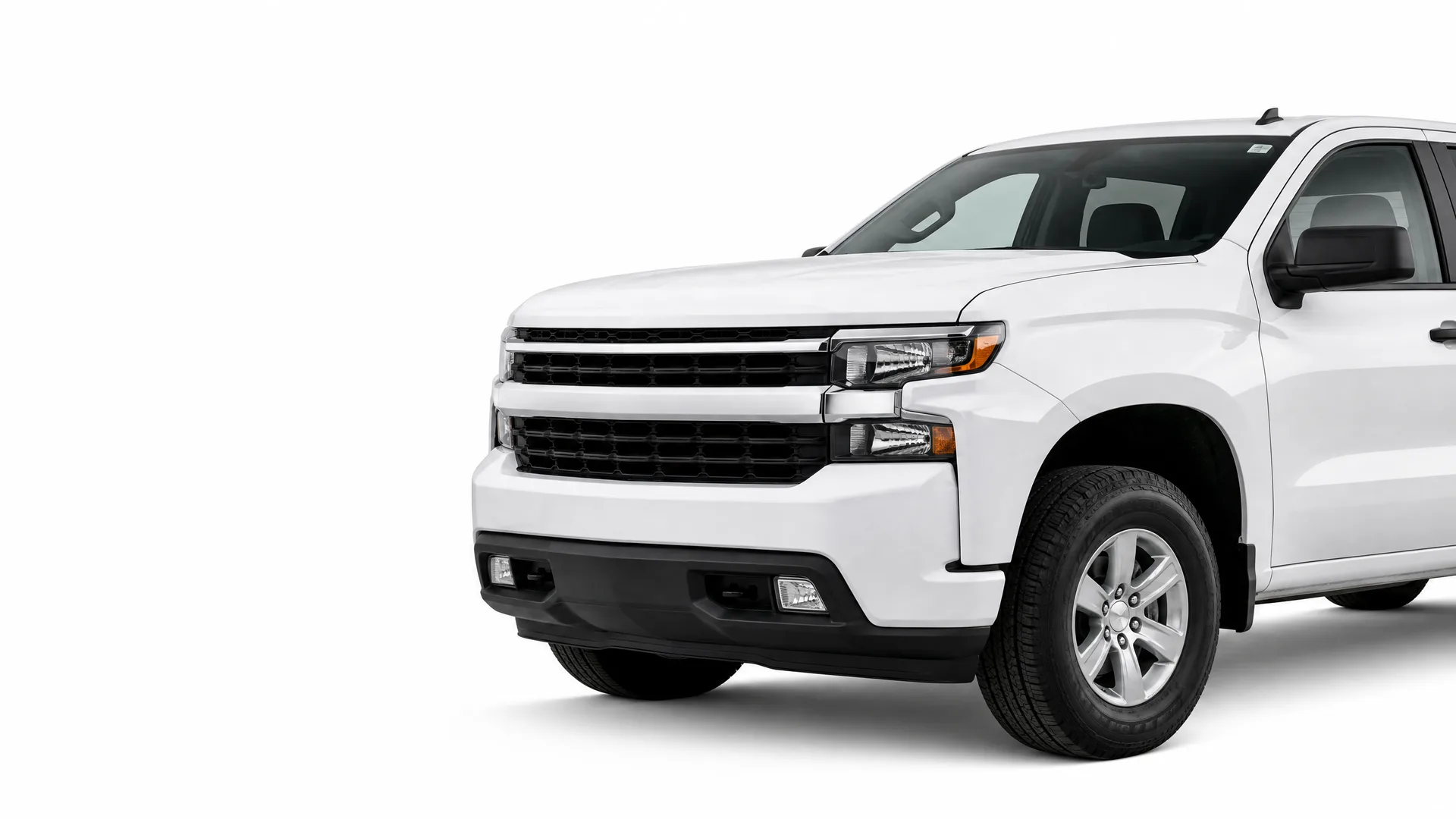Front three-quarter view of a white pickup truck with a black grille and bumper, photographed against a plain white background.