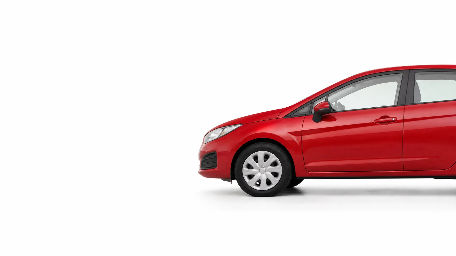 Front half of a red hatchback car shown in side view against a plain white background, with the rear of the vehicle cropped off at the right edge.