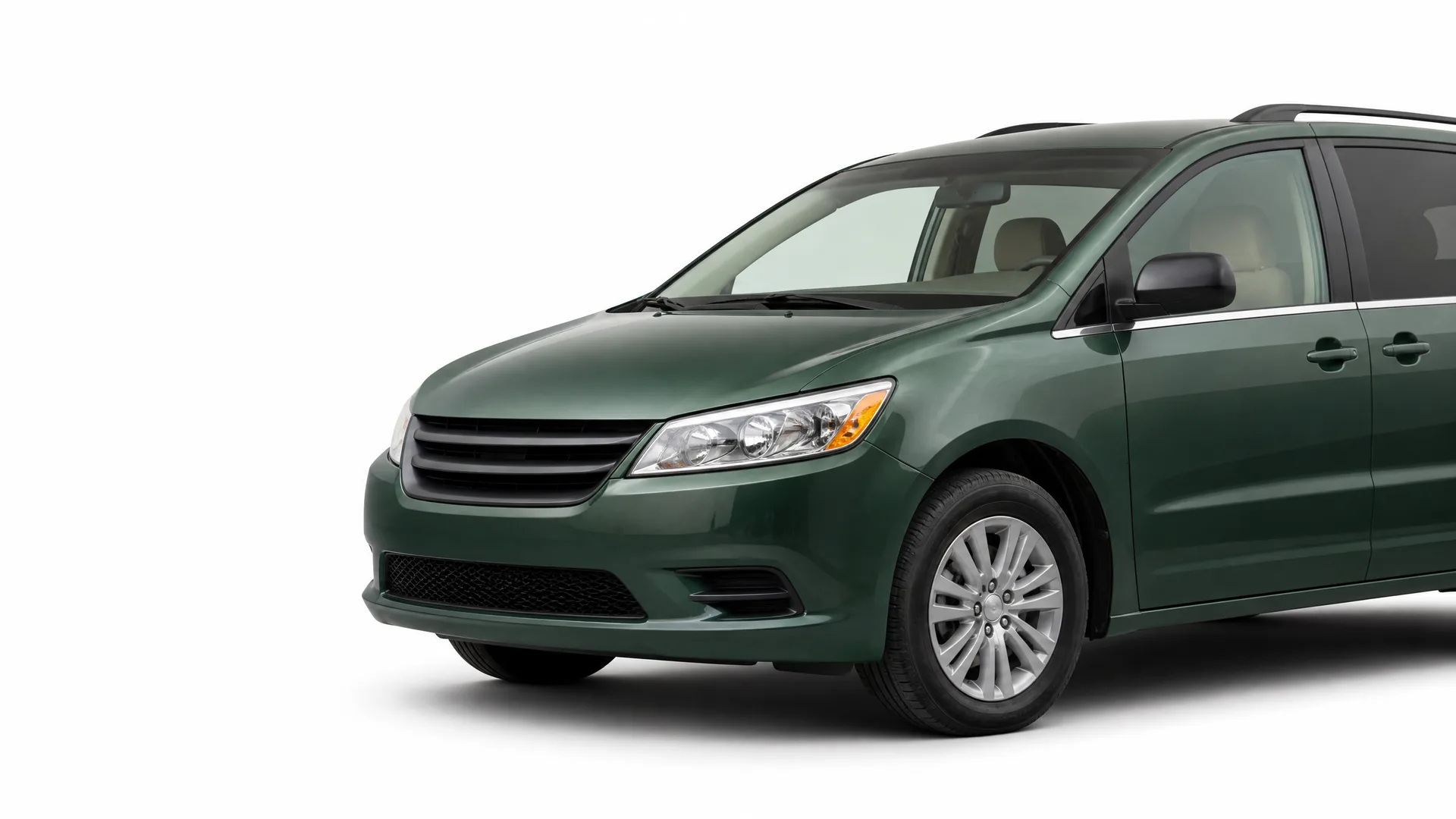 A dark green minivan shown from the front-left three-quarter angle against a plain white background.