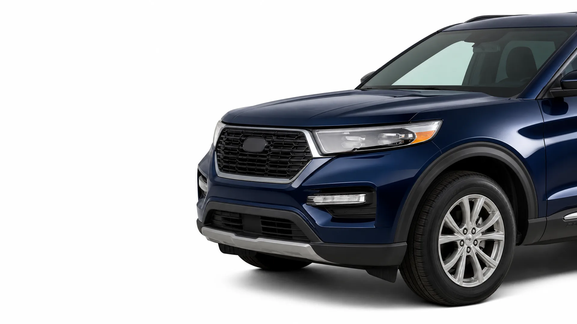 Front three-quarter view of a dark blue SUV with a chrome-trimmed black grille and alloy wheels against a plain white background.