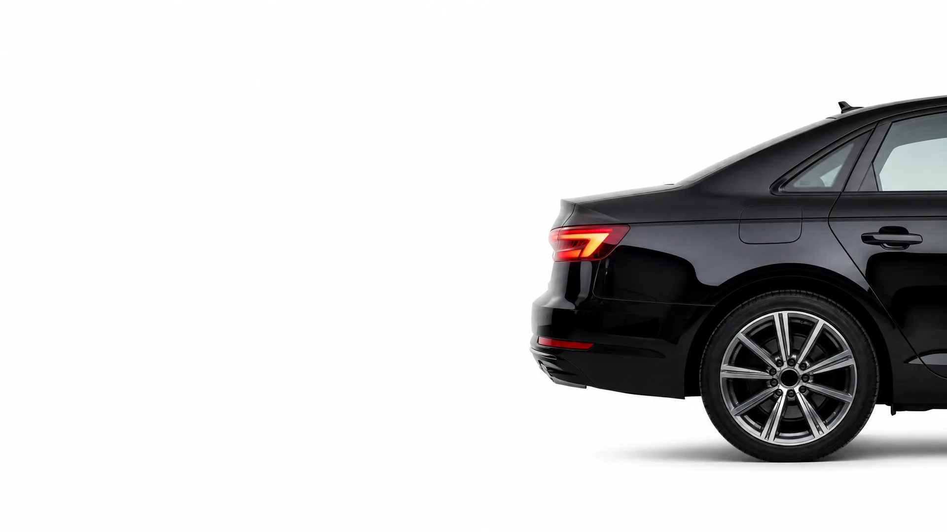 Rear half of a black four-door sedan with a multi-spoke alloy wheel, shown against a plain white background.