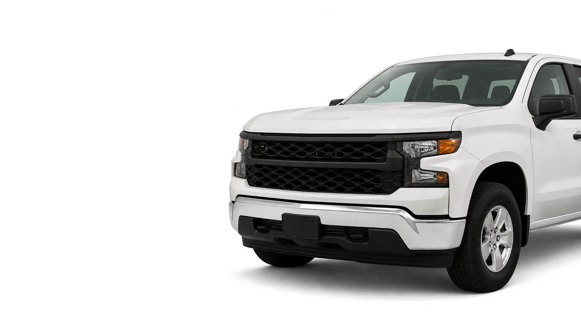 Front three-quarter view of a white pickup truck with a black grille and bumper, photographed against a plain white background.
