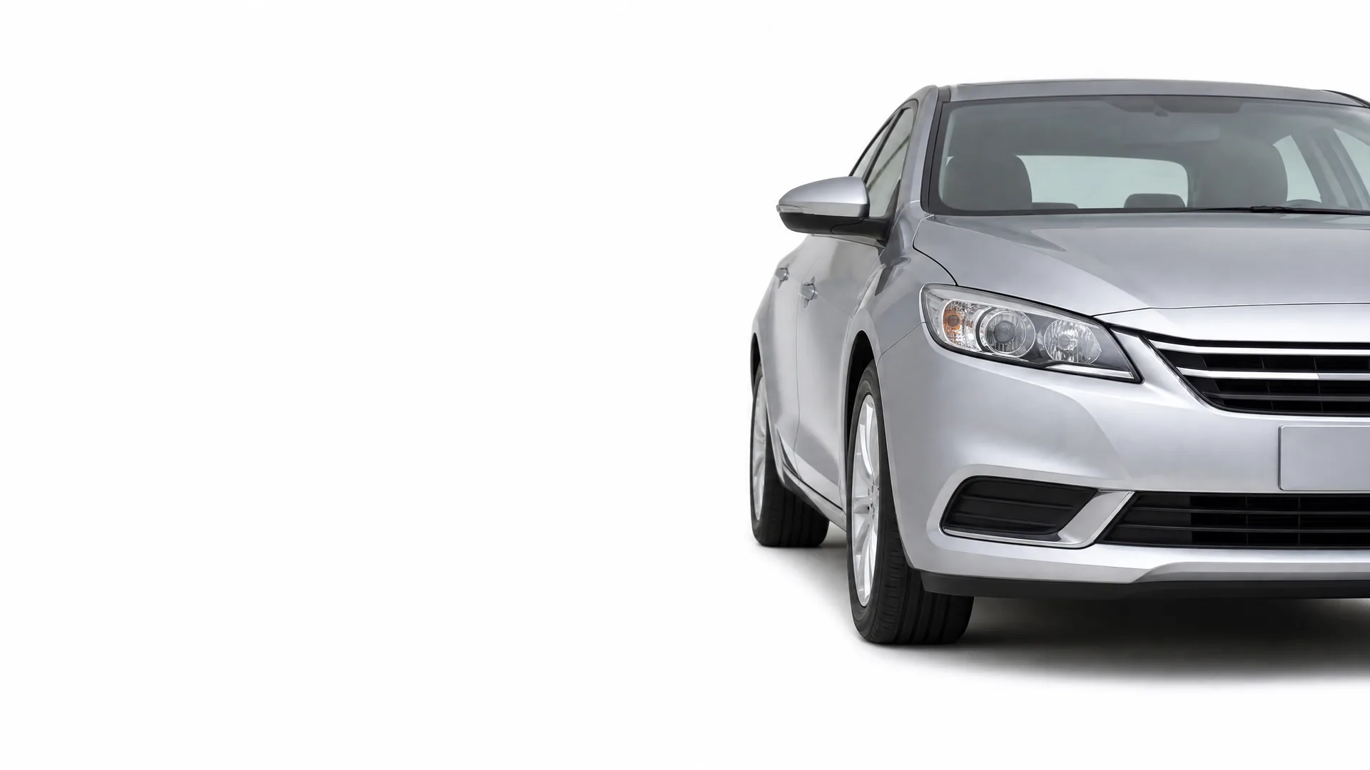 Front left portion of a silver four-door sedan against a plain white background, with the rest of the frame empty.