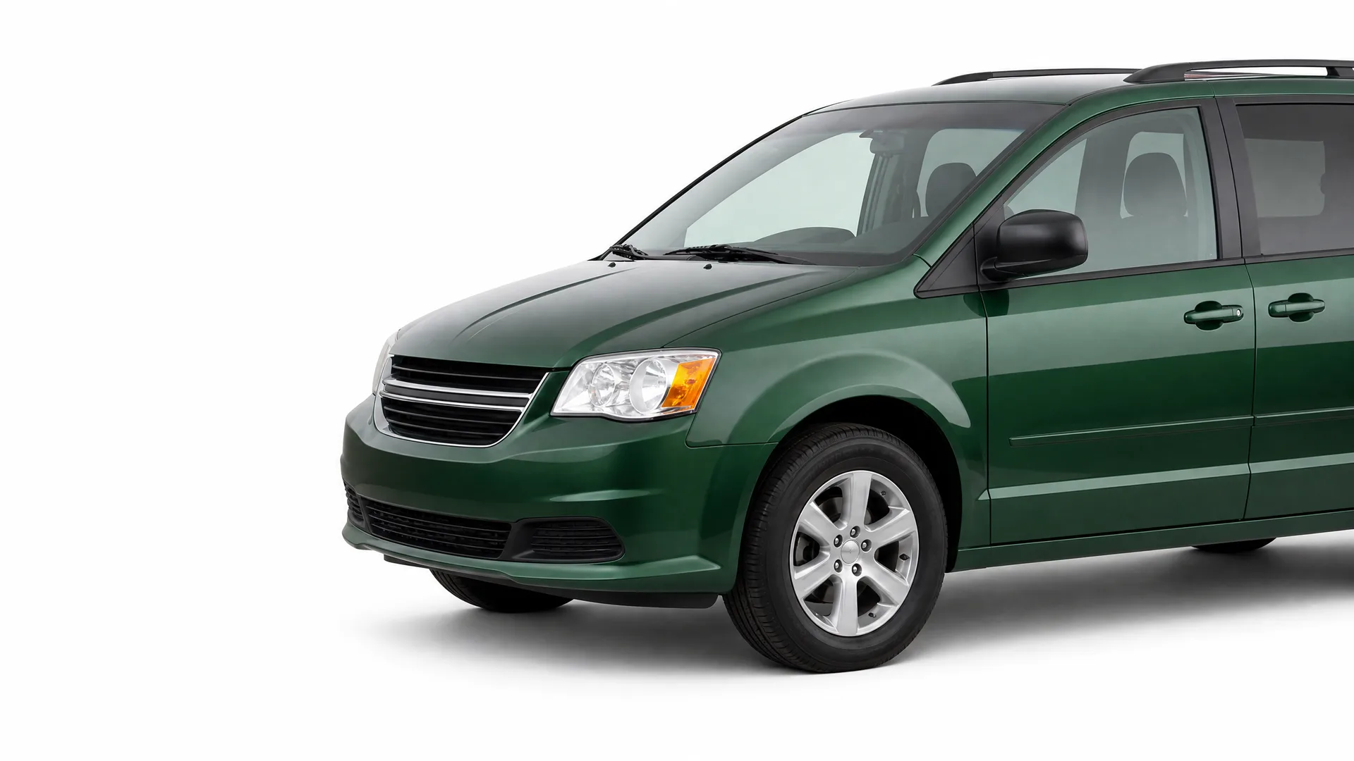 Dark green minivan shown from a front three-quarter angle against a plain white background, with the rear of the vehicle cropped off at the right edge.