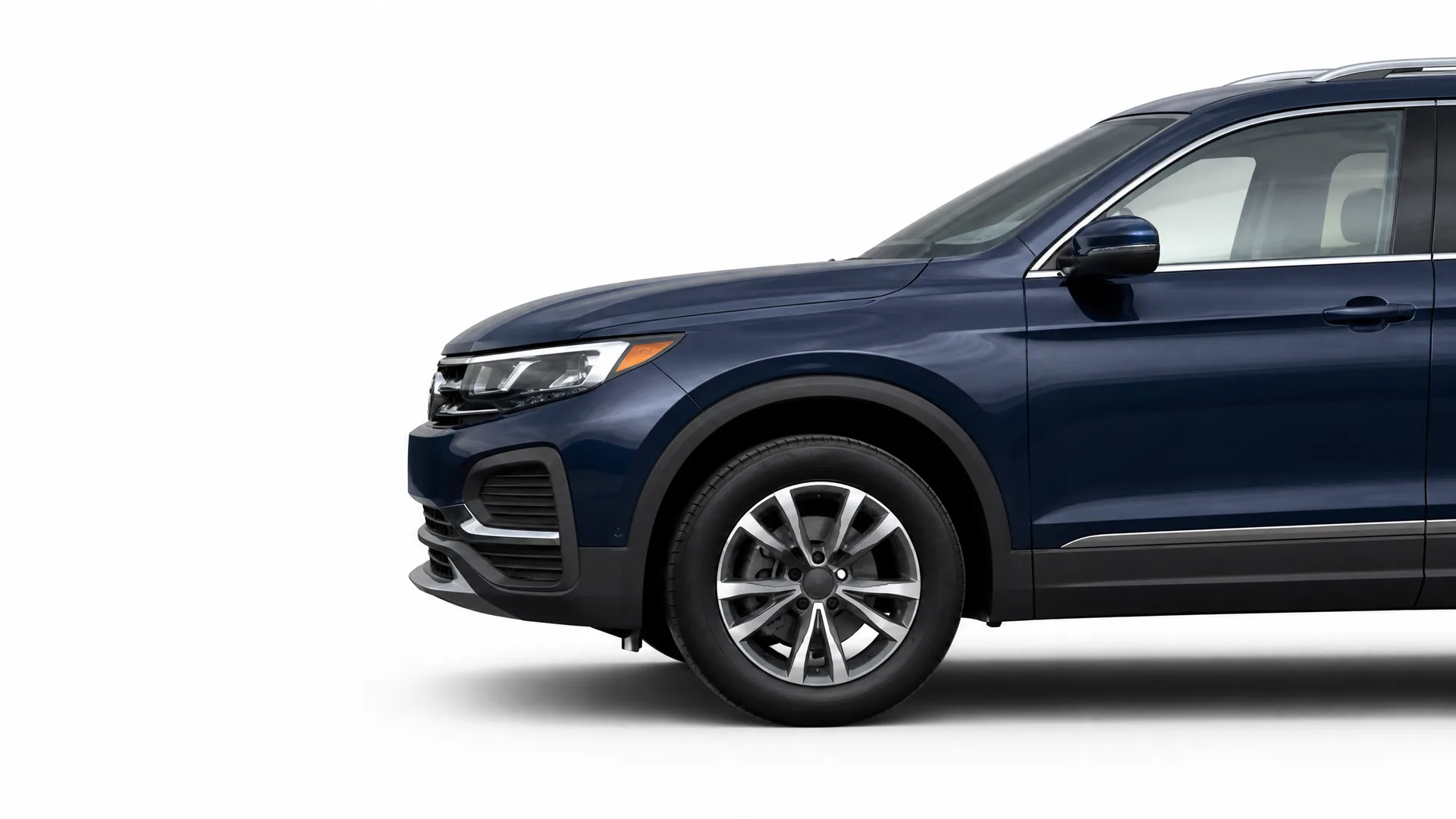 Front and partial side view of a dark blue SUV on a plain white background, showing the headlight, front bumper, front wheel with alloy rim, and side mirror.