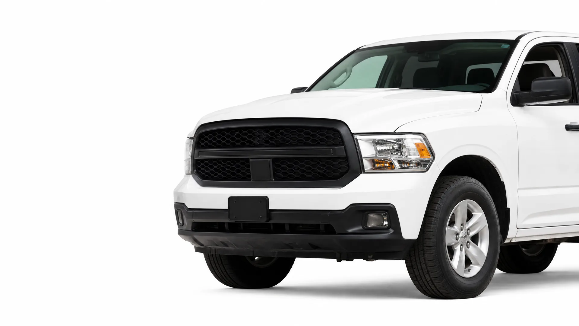 Front three-quarter view of a white pickup truck with a black grille and no license plate, photographed against a plain white background.
