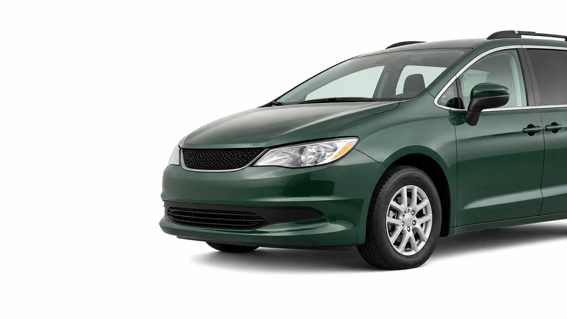 Front three-quarter view of a dark green minivan with alloy wheels and roof rails, photographed against a plain white background.