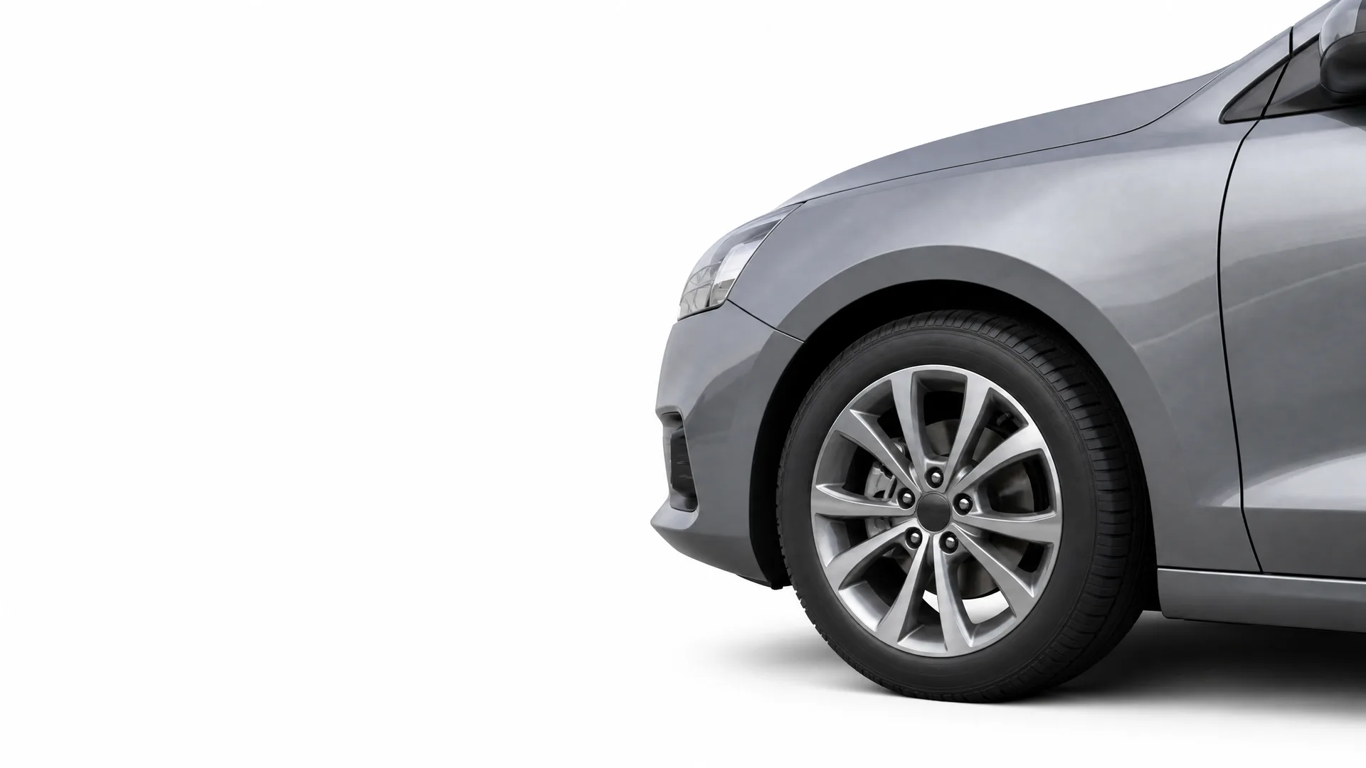 Front section of a grey car, showing the front wheel with alloy rim, fender, headlight edge and side mirror, isolated on a white background.