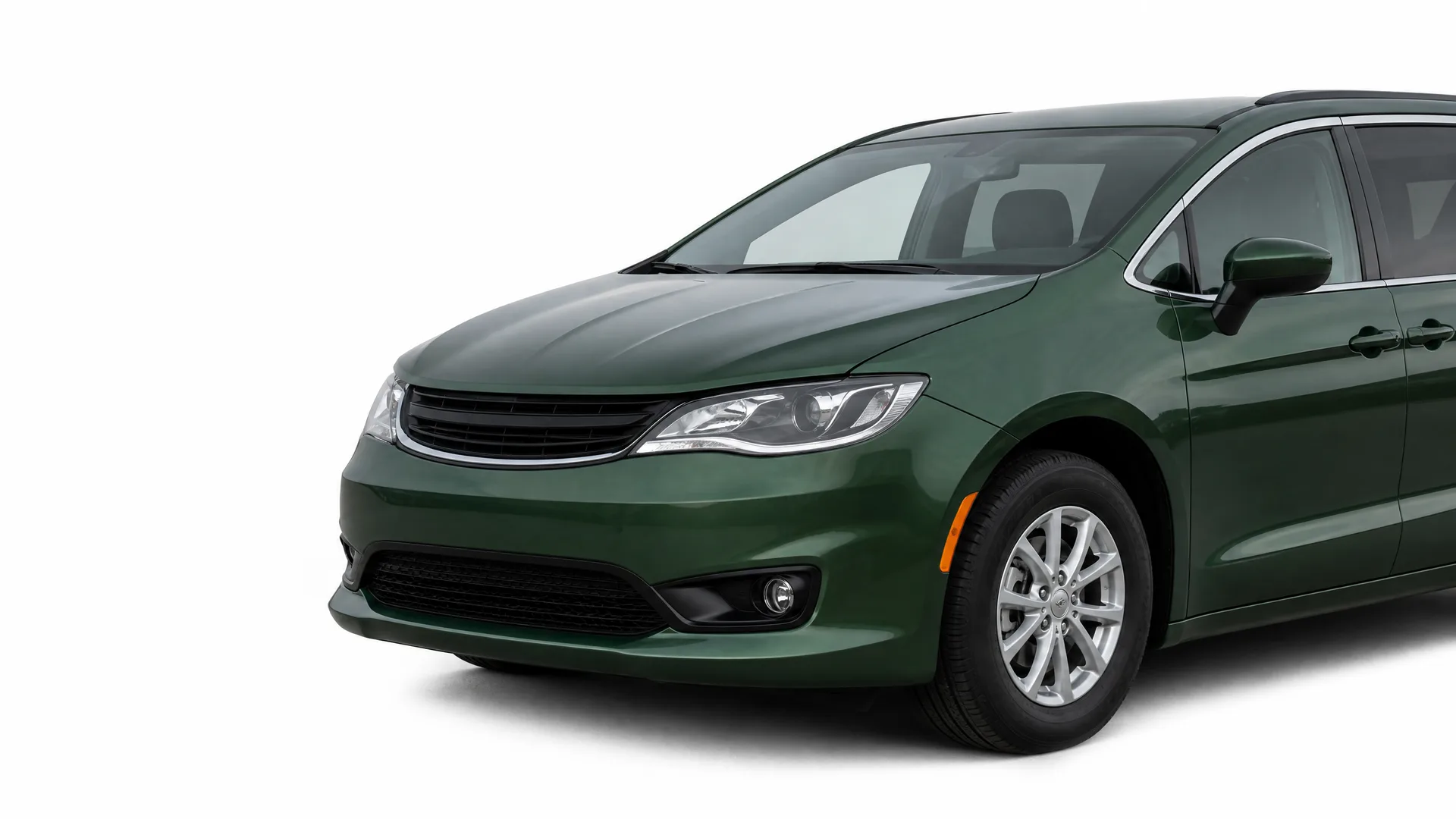 Front three-quarter view of a dark green minivan on a plain white background, showing the hood, grille, headlight, front wheel and driver-side windows.