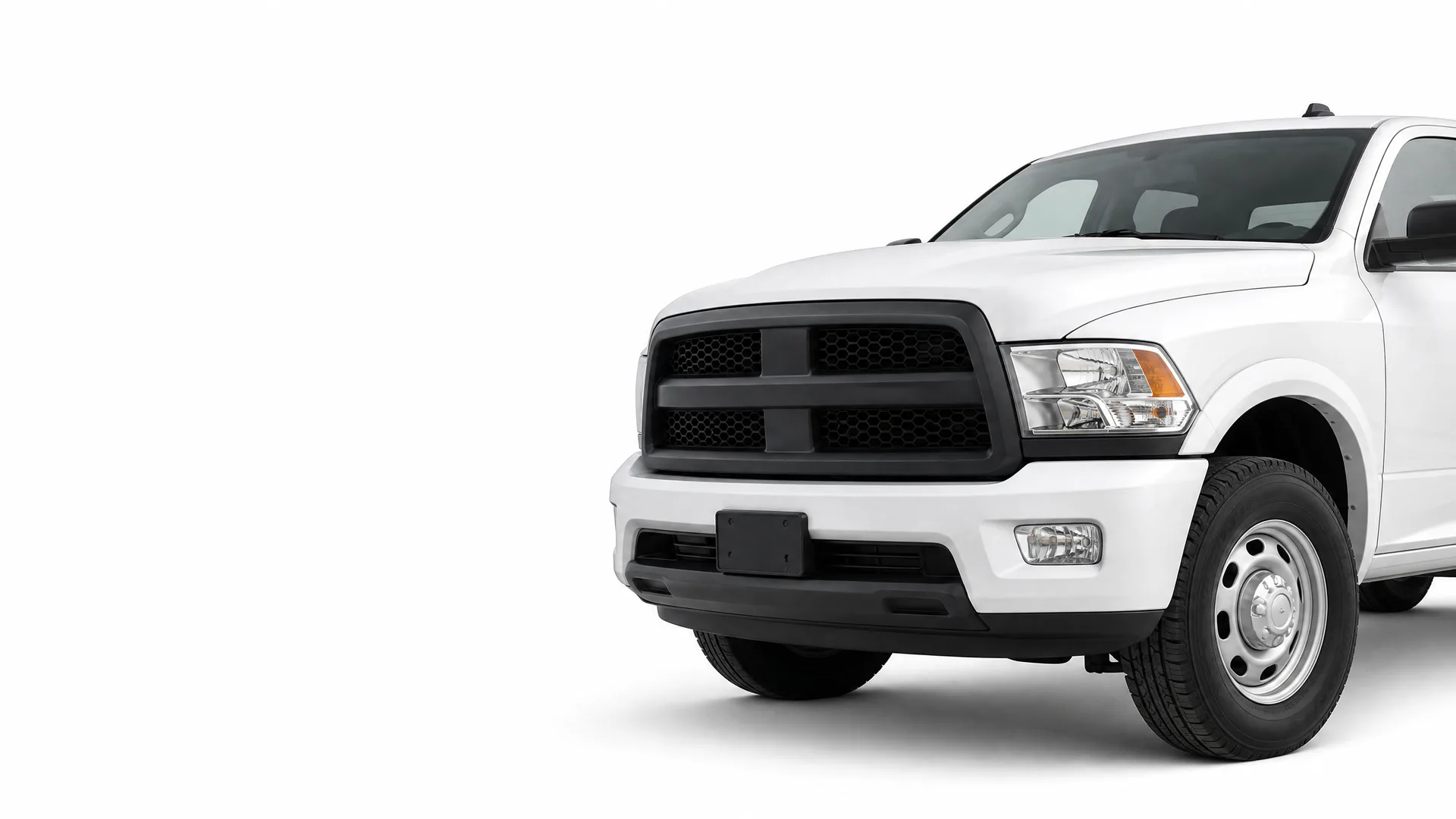 Front three-quarter view of the front half of a white pickup truck with a black grille and steel wheels, isolated on a white background.