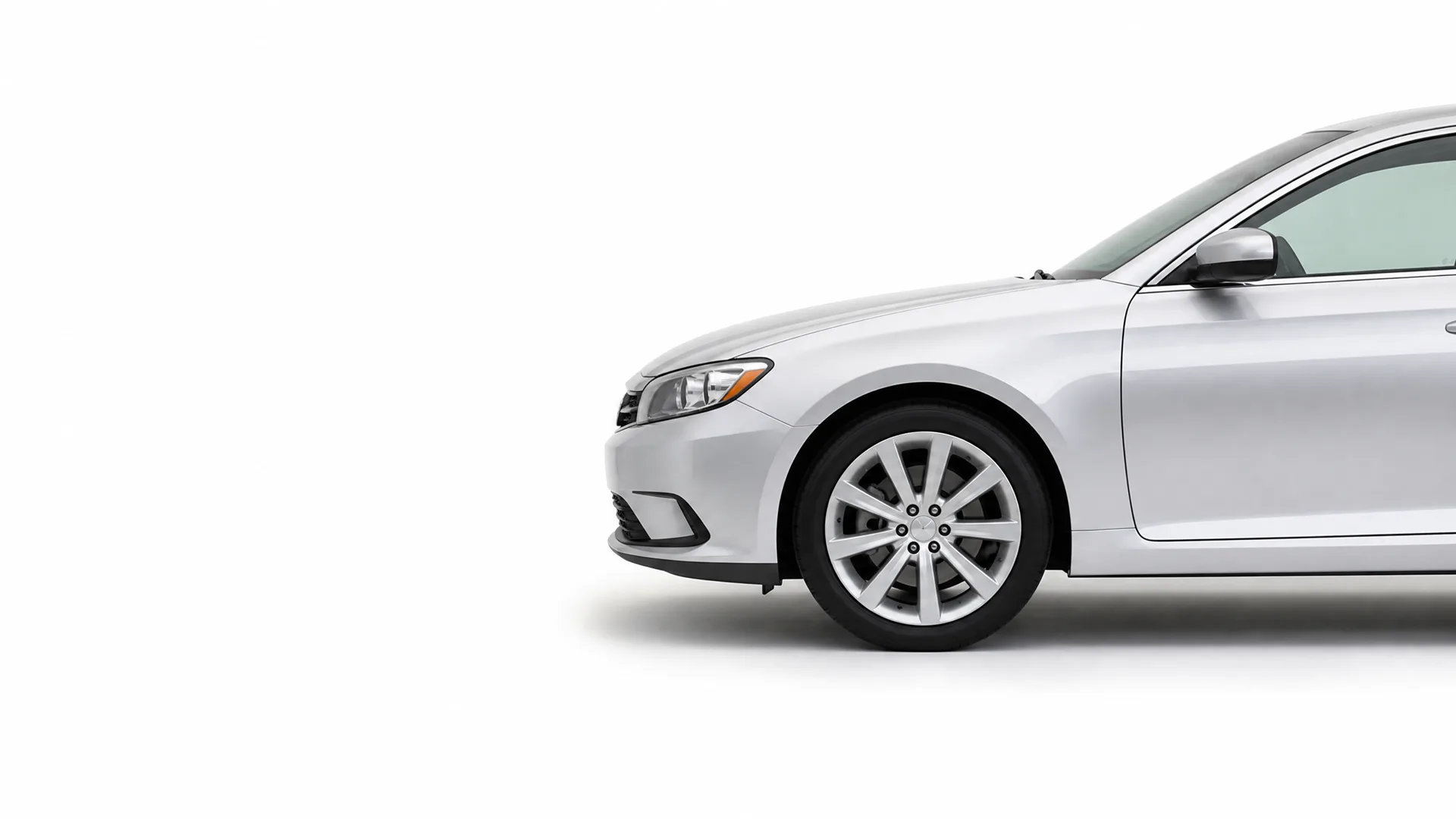 Front half of a silver four-door sedan, shown in profile against a plain white background with a soft shadow beneath it.