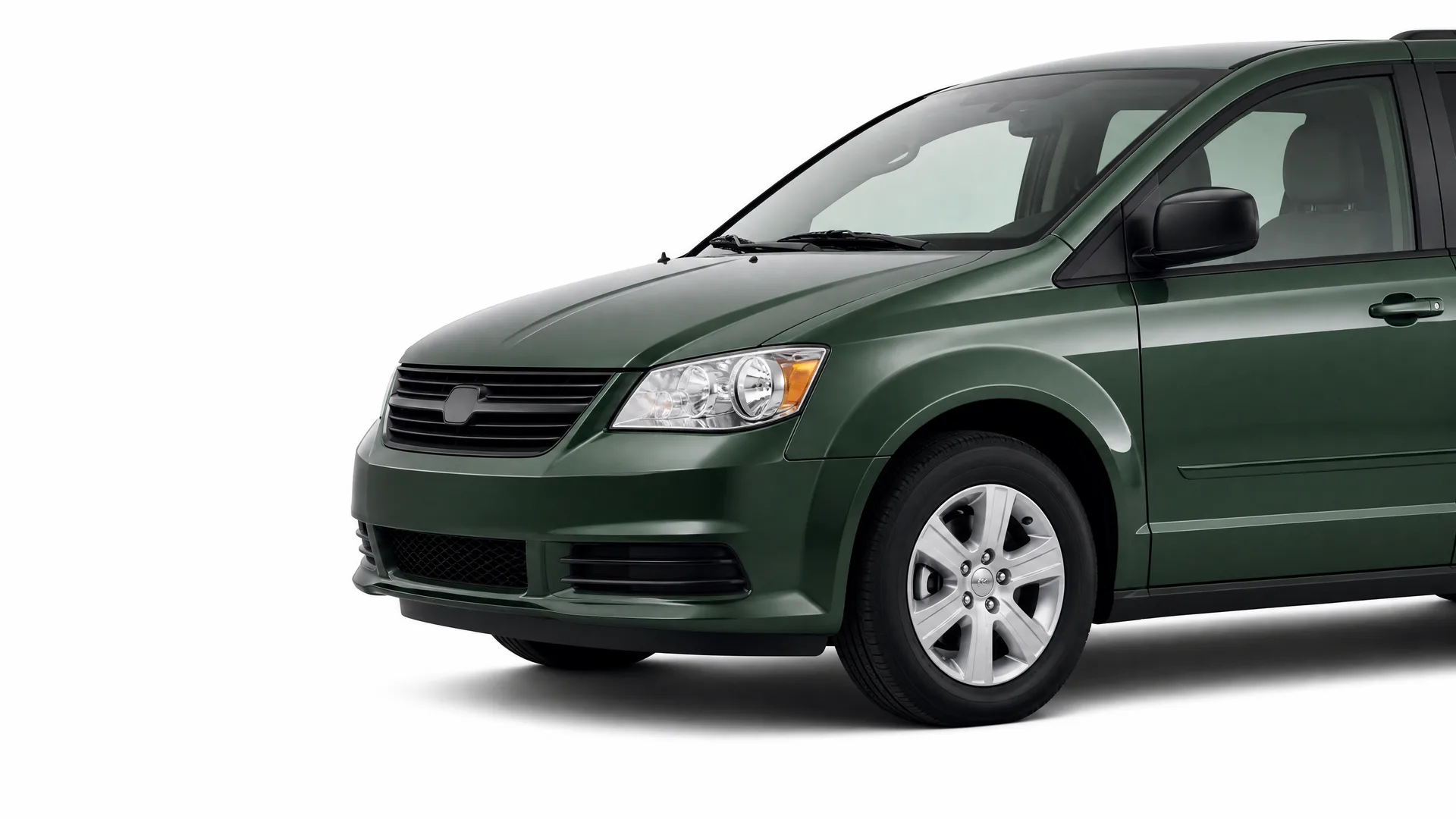 Front three-quarter view of a dark green minivan, cropped at the rear, photographed against a plain white background.
