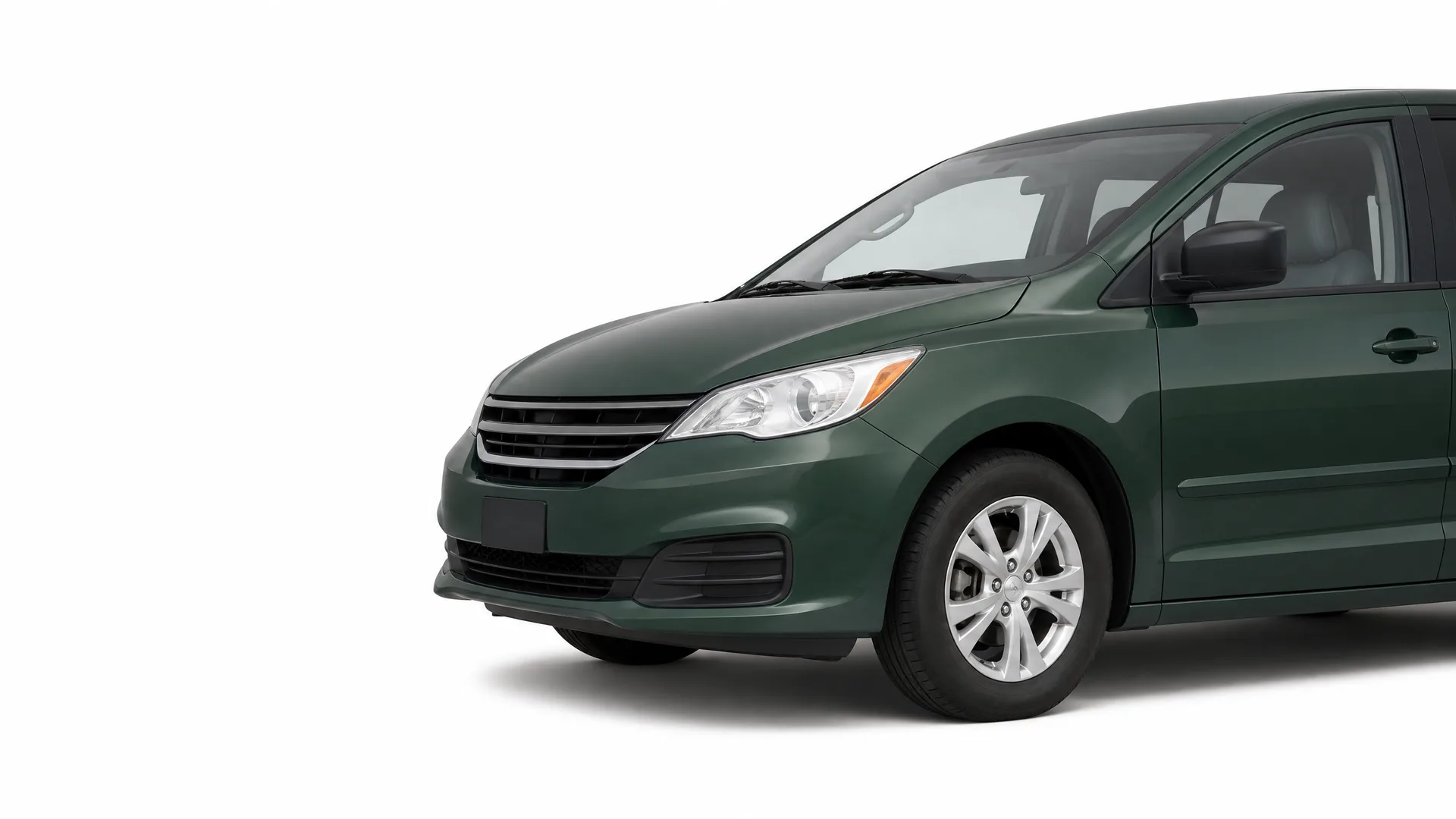 Front three-quarter view of a dark green minivan, partially cropped at the rear, on a plain white background.