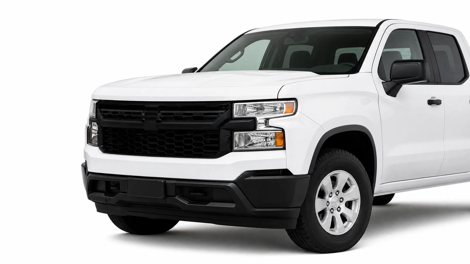 A white crew-cab pickup truck with a black grille and bumper, photographed from the front left against a plain white background.