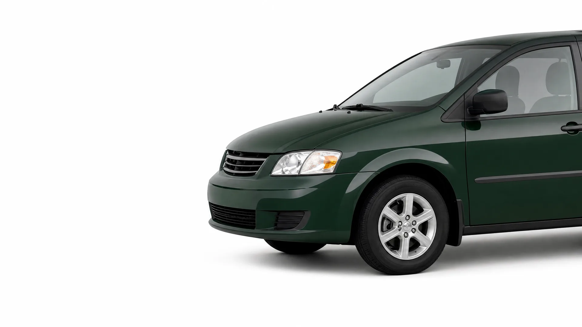 Front three-quarter view of a dark green minivan, partially cropped at the rear, against a plain white background.