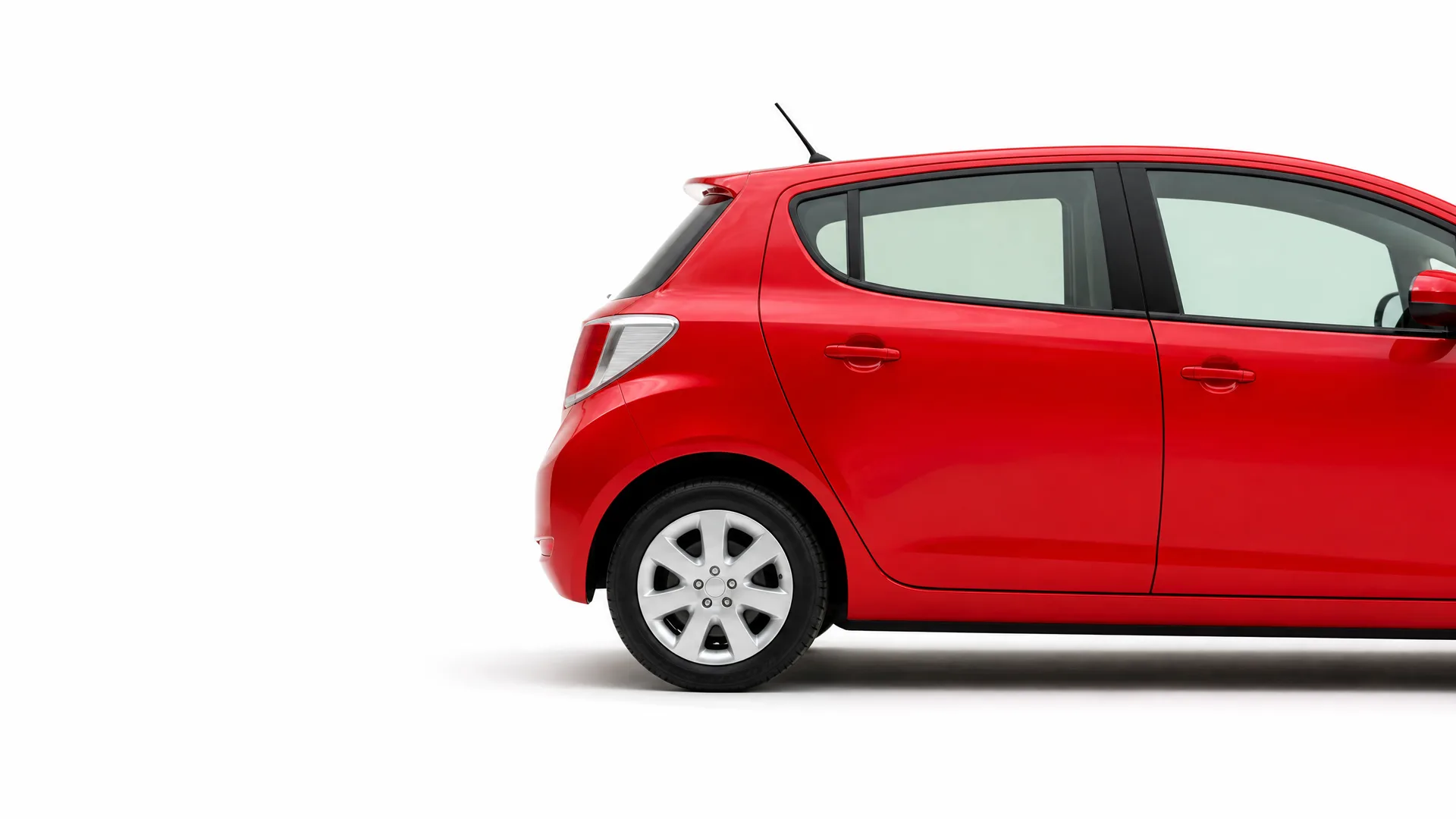 Rear half of a red five-door hatchback car shown in profile against a plain white background.