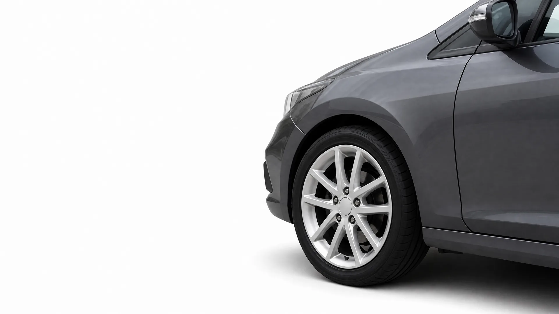 Partial view of the front right side of a dark grey car with an alloy wheel, shown against a plain white background.