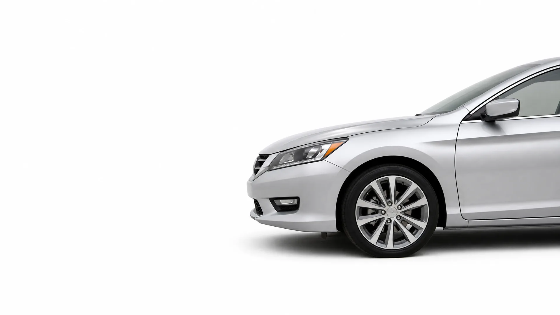 Front half of a silver four-door sedan, shown in profile against a plain white background with a soft shadow beneath.
