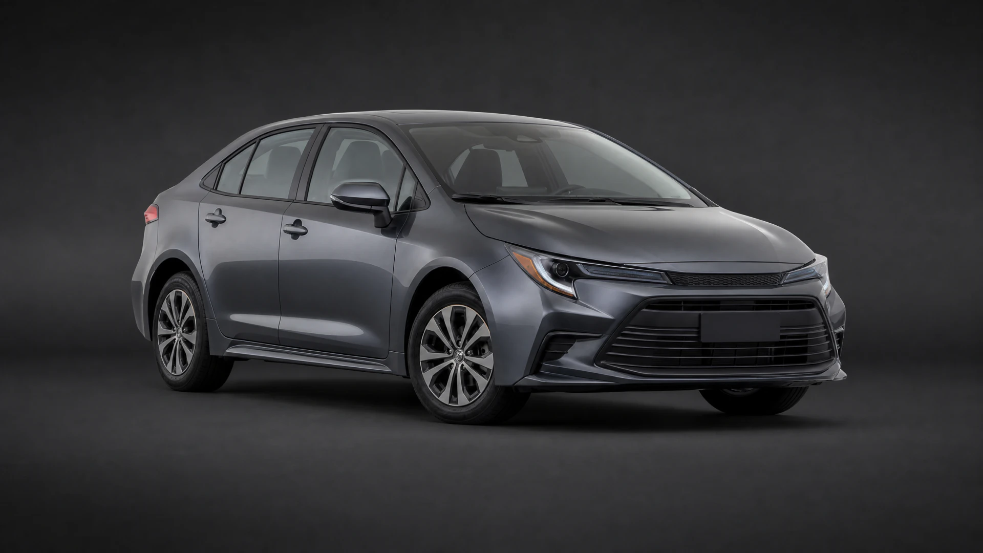 A dark gray four-door sedan photographed in a professional studio setting against a dark background.
