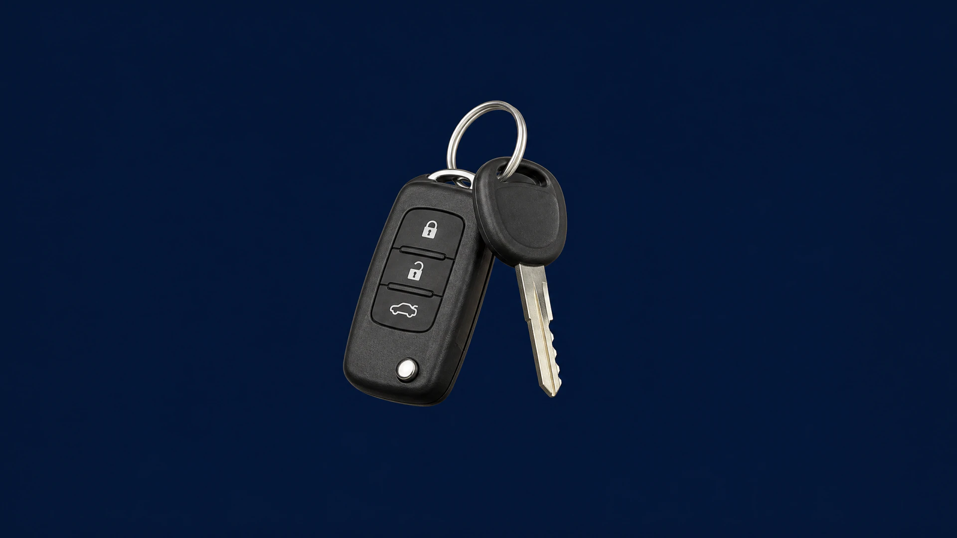 A black flip car key fob with three function buttons, attached to a cut metal ignition key and a small black valet key on a metal ring.