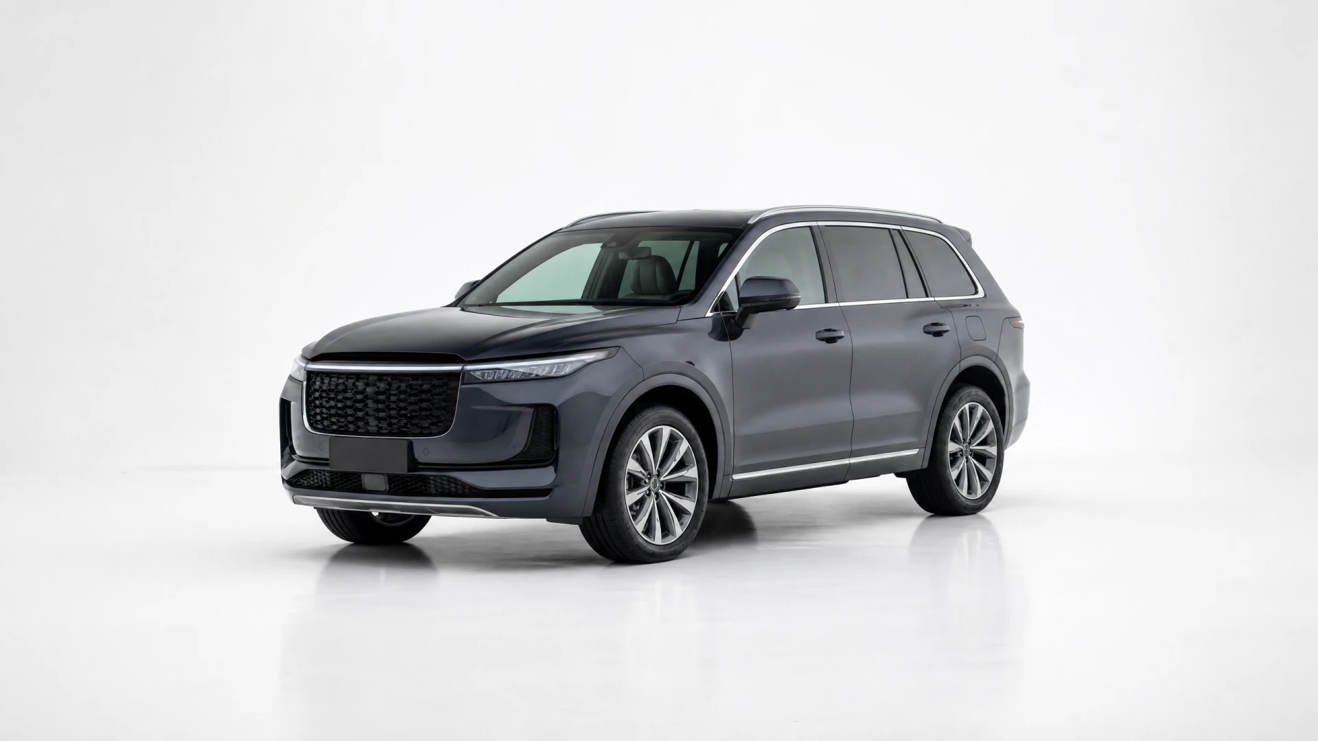 A dark gray three-row SUV with a wide mesh grille and chrome window trim, photographed against a white studio background.