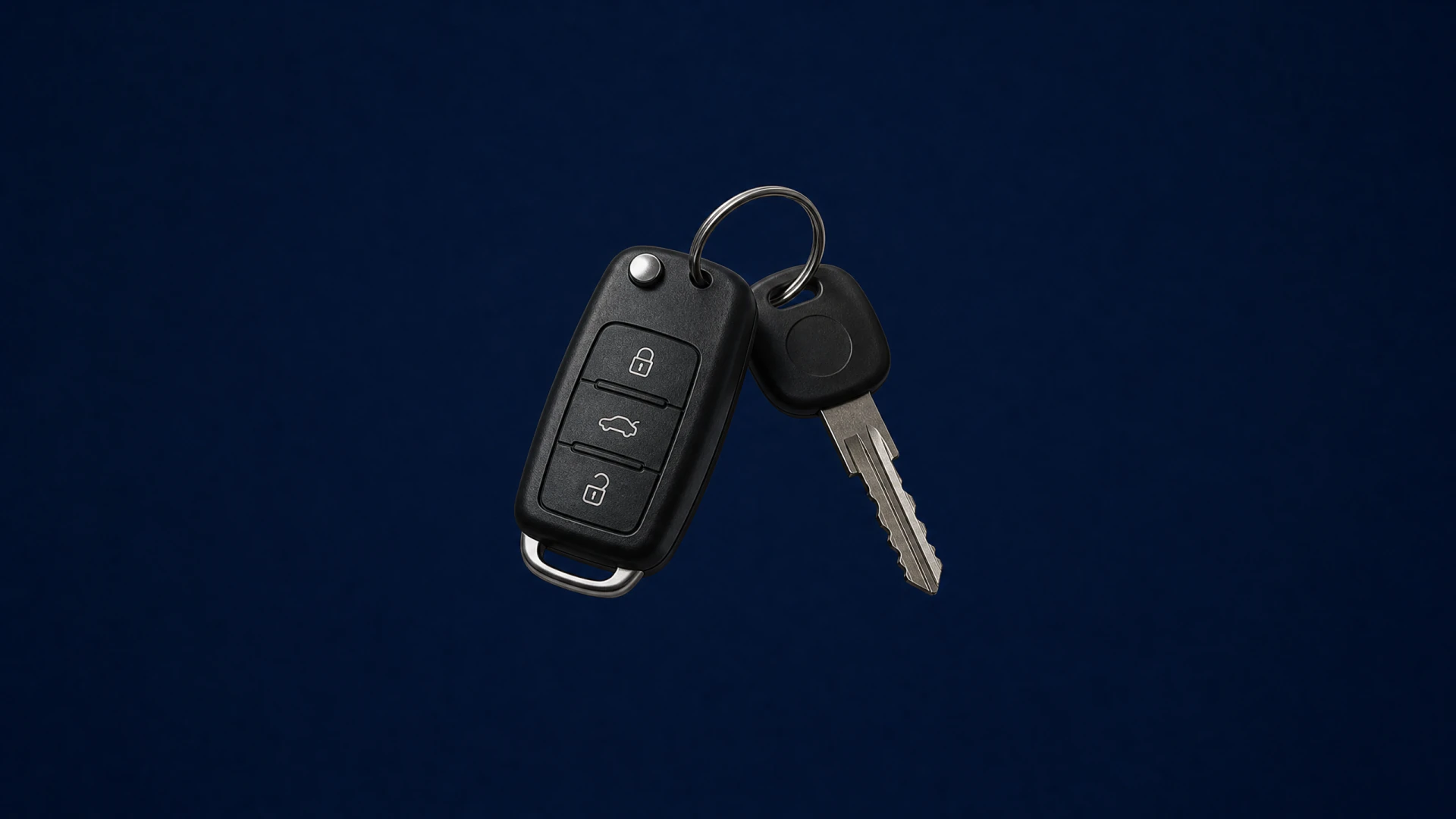 A black flip car key fob and a metal car key connected by a metal key ring.