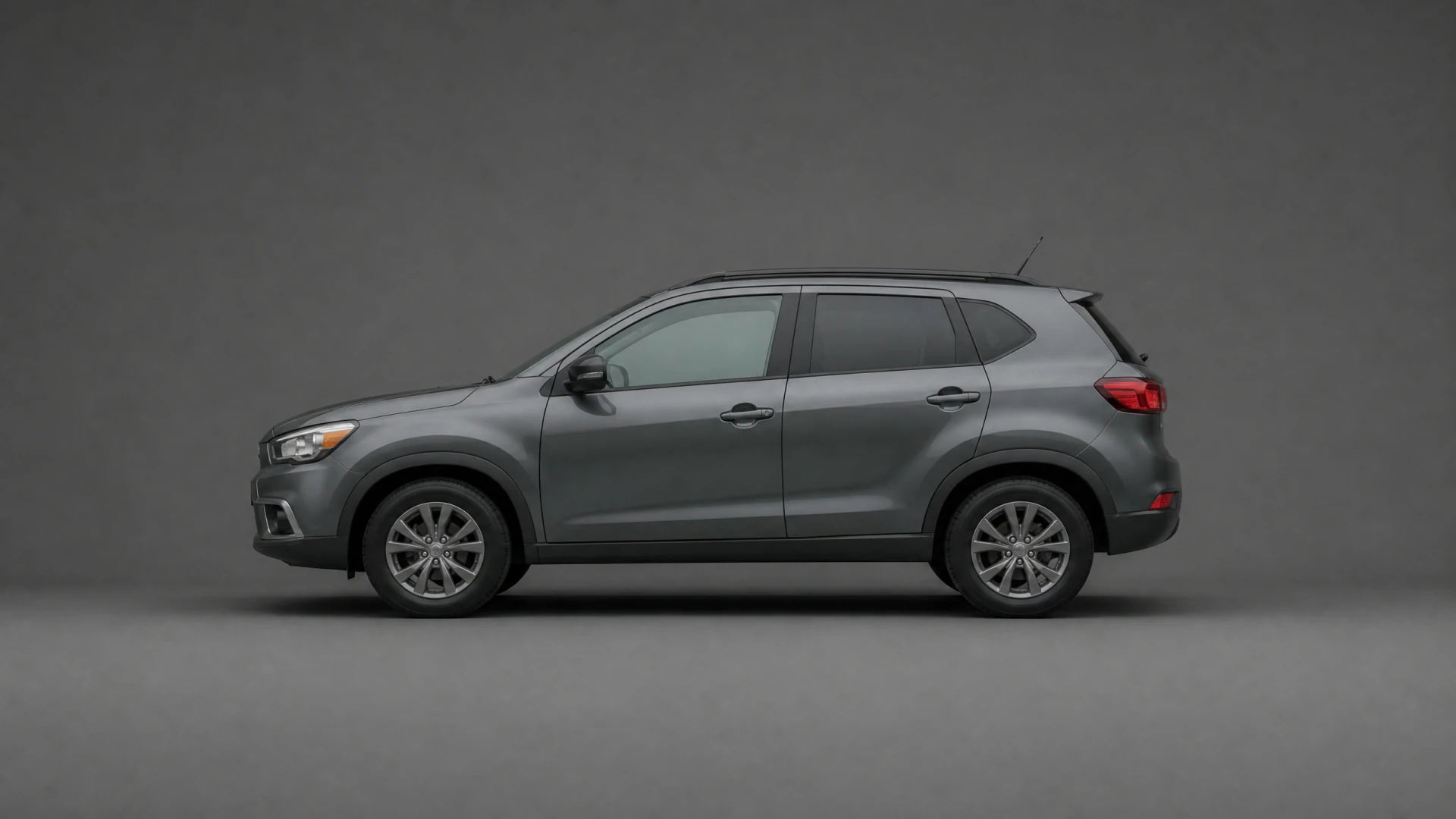 A gray five-door compact SUV shown from the side in a studio setting with a plain gray background.