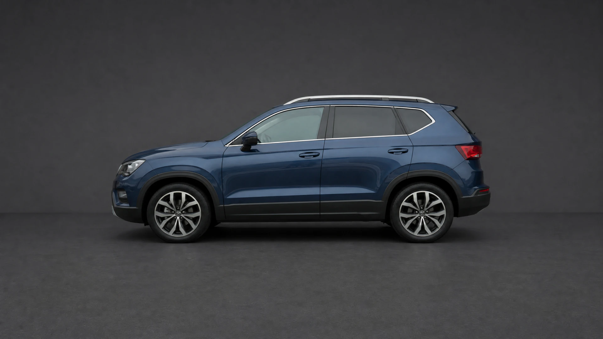 A dark blue five-door SUV shown in profile view against a grey studio background.