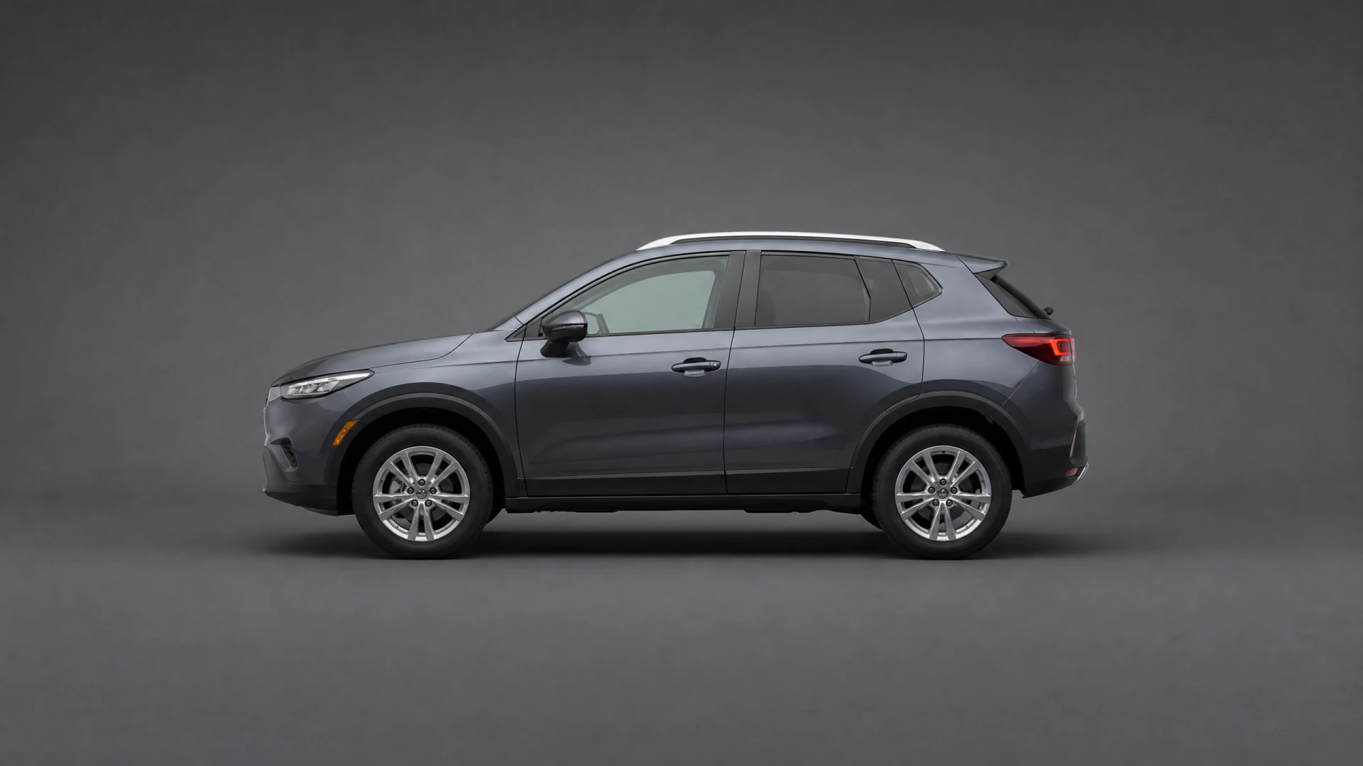 A dark gray five-door compact SUV photographed in profile against a gray studio background.
