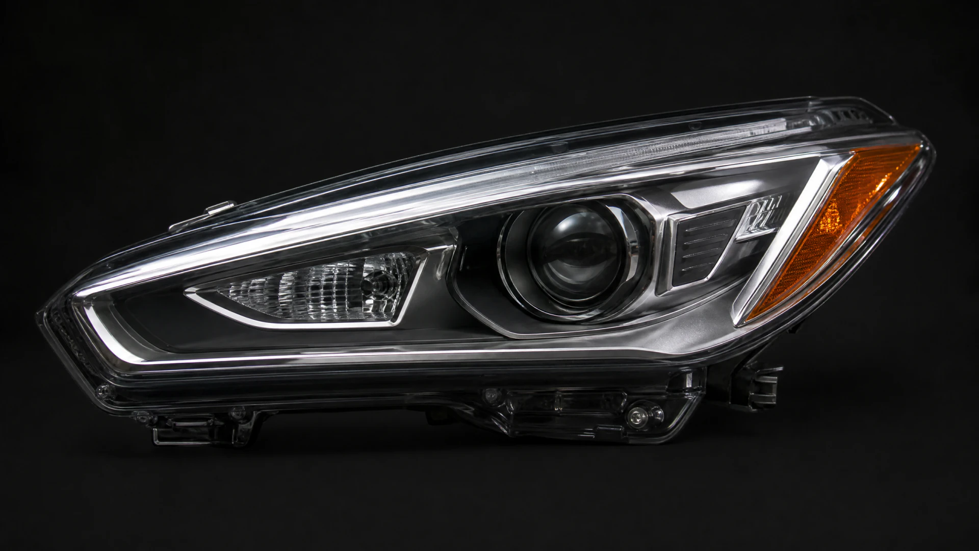 An isolated automotive headlight assembly with a projector lens, amber turn signal, and chrome trim, photographed against a black background.