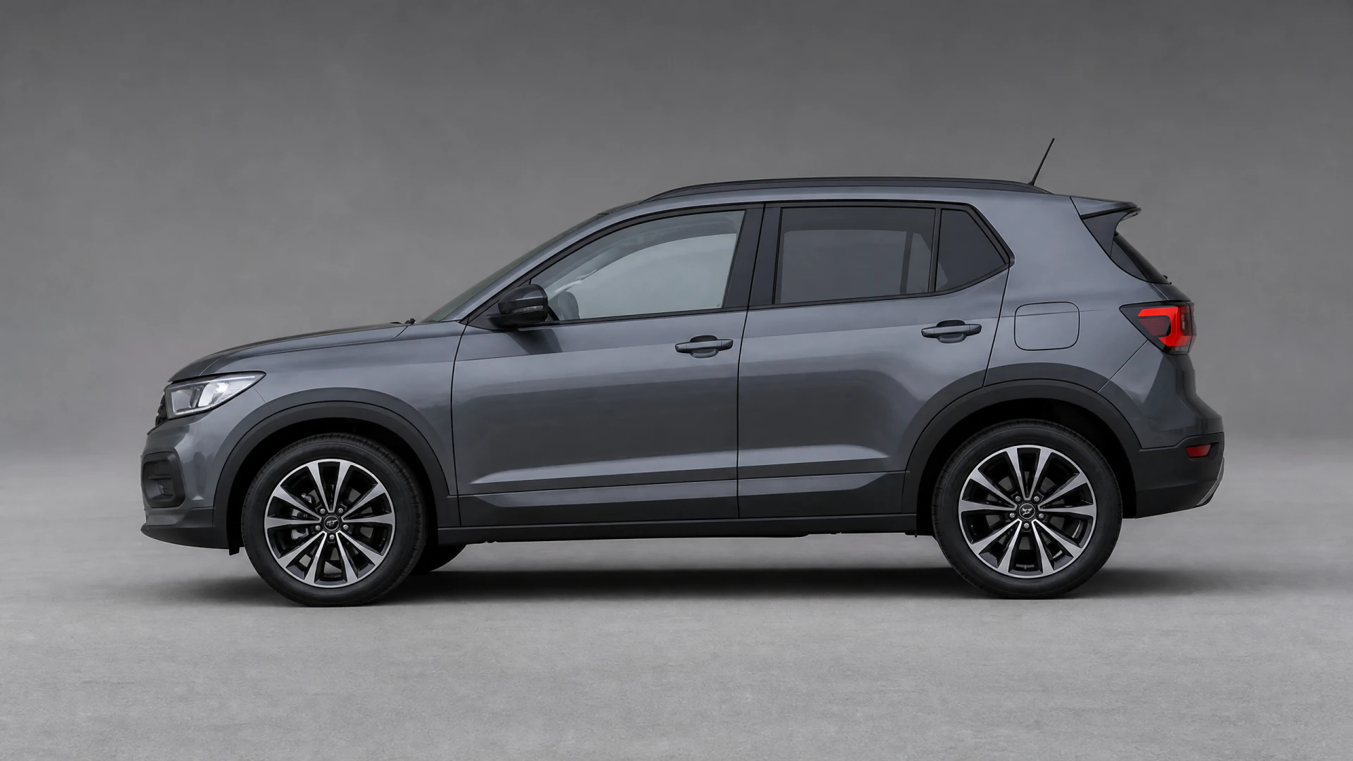 A dark grey compact SUV shown in side profile against a plain grey studio backdrop.