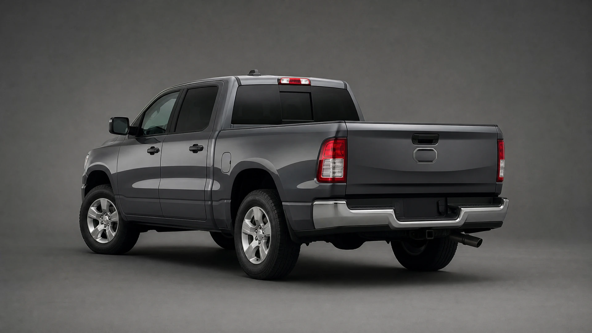 A dark gray crew-cab pickup truck photographed from the rear three-quarter angle in a studio environment.