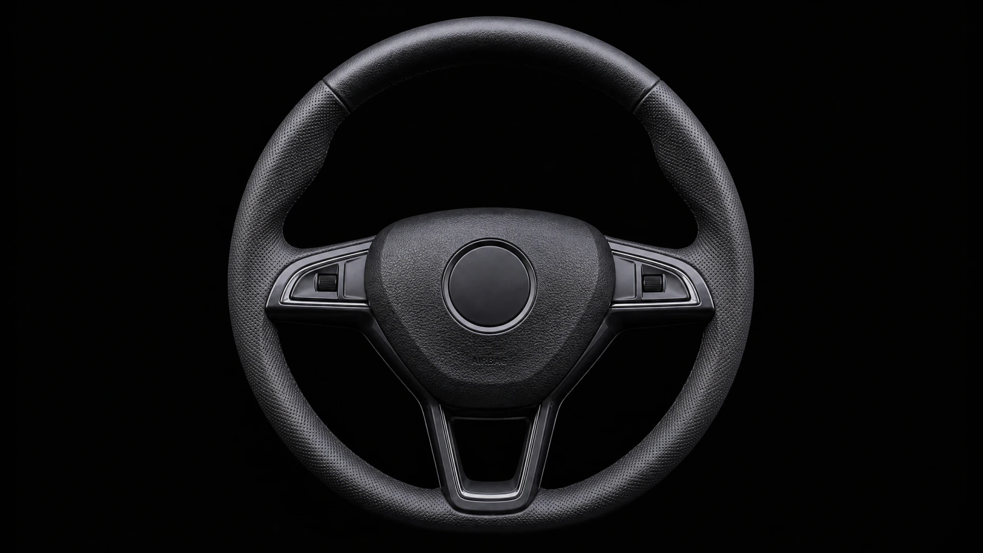 A black leather three-spoke car steering wheel with integrated controls, photographed head-on against a black background.