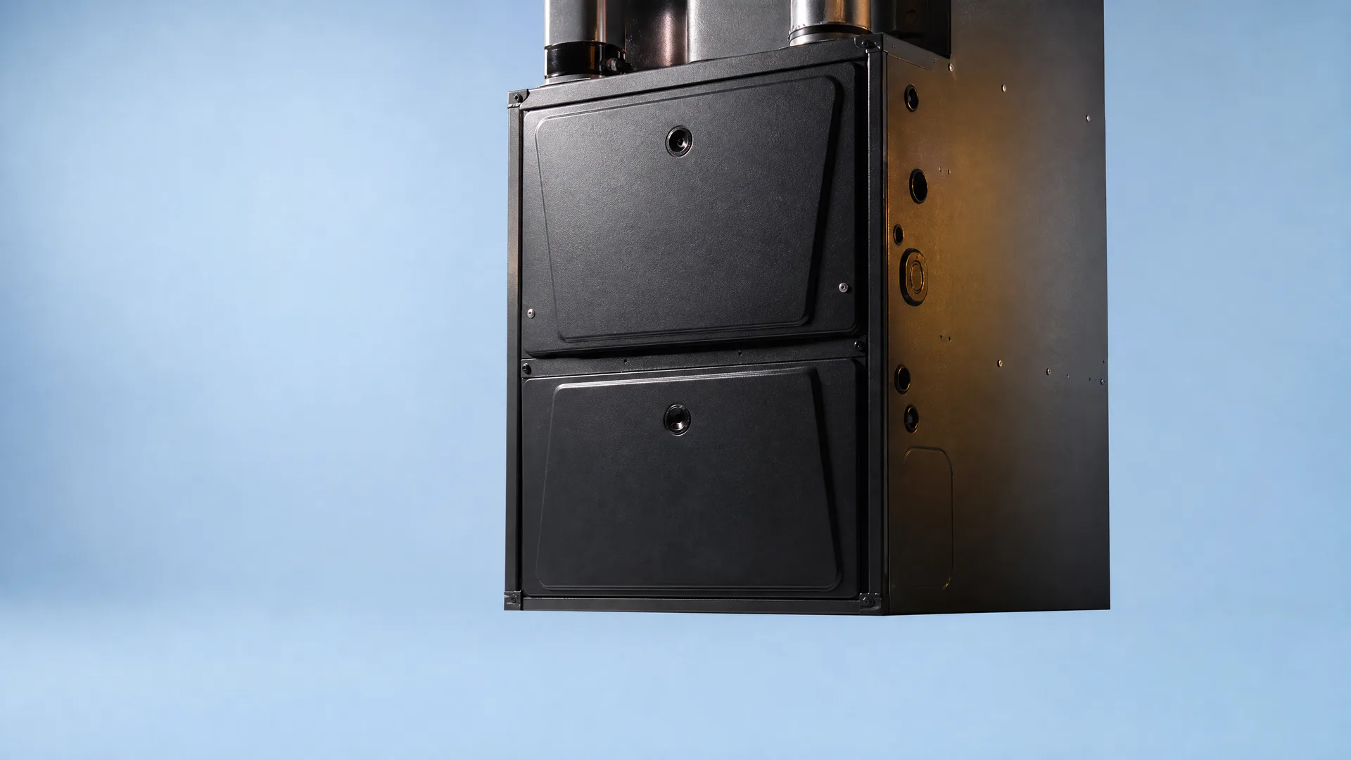 A black furnace cabinet with two access panels and metal pipes at the top, shown against a plain blue background.