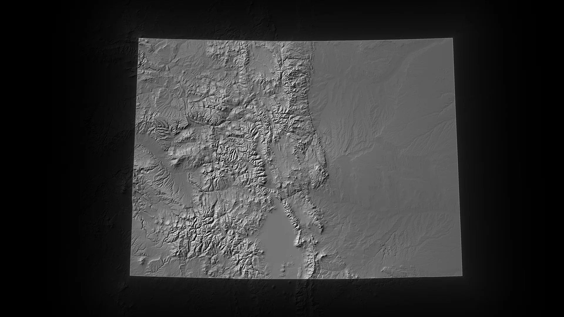 Relief map of Colorado, its terrain lit, the neighbouring states fading into the dark